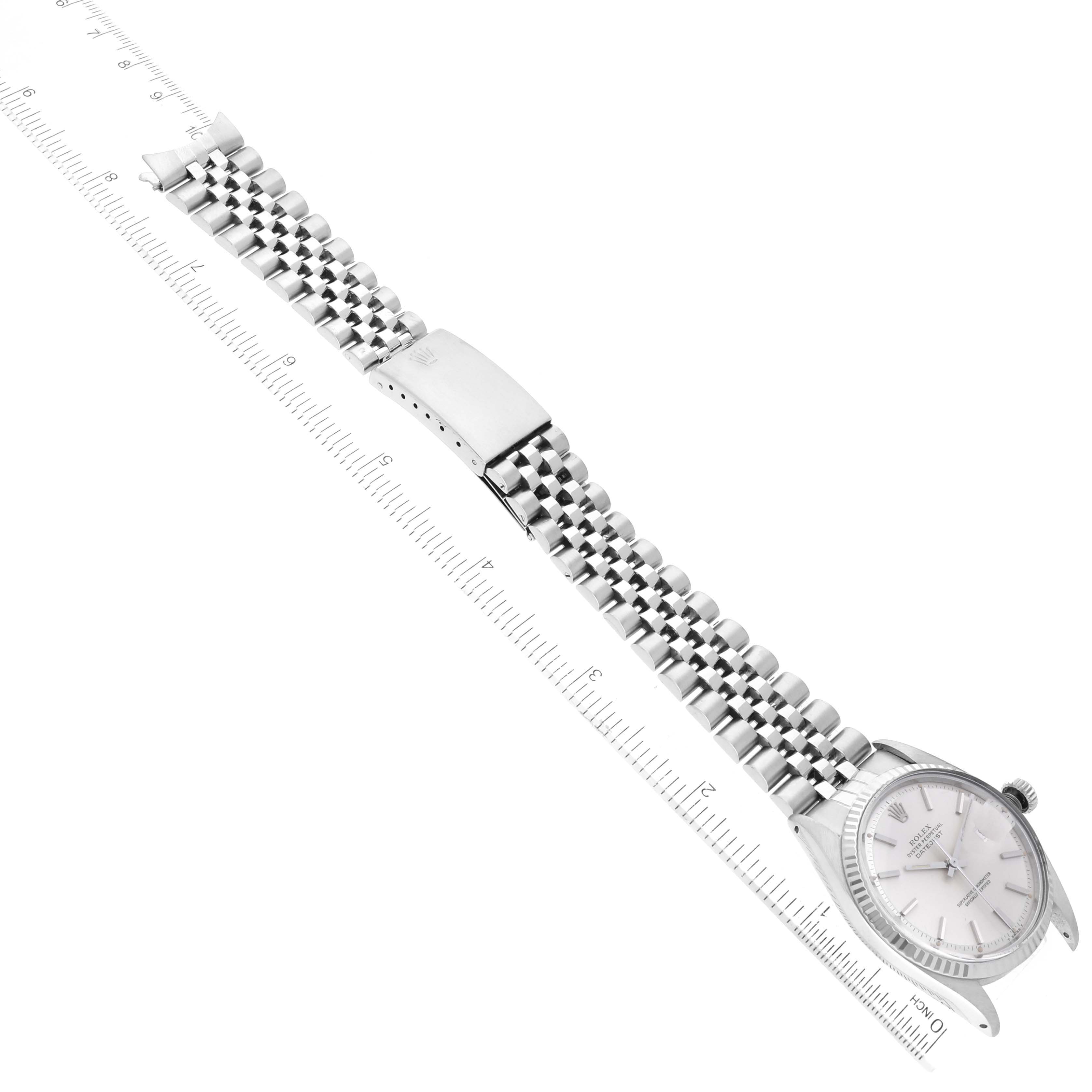 The image shows a top-down view of a Rolex Datejust 1601 Men's Stainless Steel Silver Dial 1601 Men's Stainless Steel Silver Dial watch, including the face, bezel, bracelet, and clasp placed alongside a ruler.