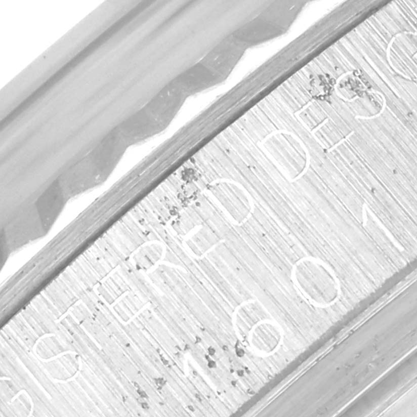 This image shows a macro shot of the serial number and fluted bezel of a Rolex Datejust 1601 Men's Stainless Steel Silver Dial 1601 Men's Stainless Steel Silver Dial.