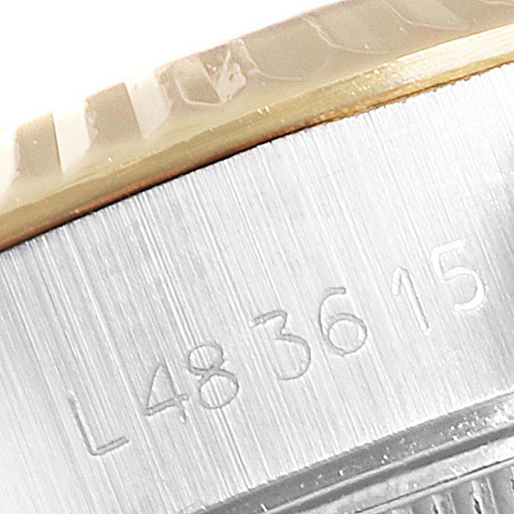 This image shows part of a Rolex Datejust 69173 Women
s Steel and Gold (two tone) Black Dial 69173 Women
s Steel and Gold (two tone) Black Dial watch, focusing on the engraved serial number and edge of the bezel.