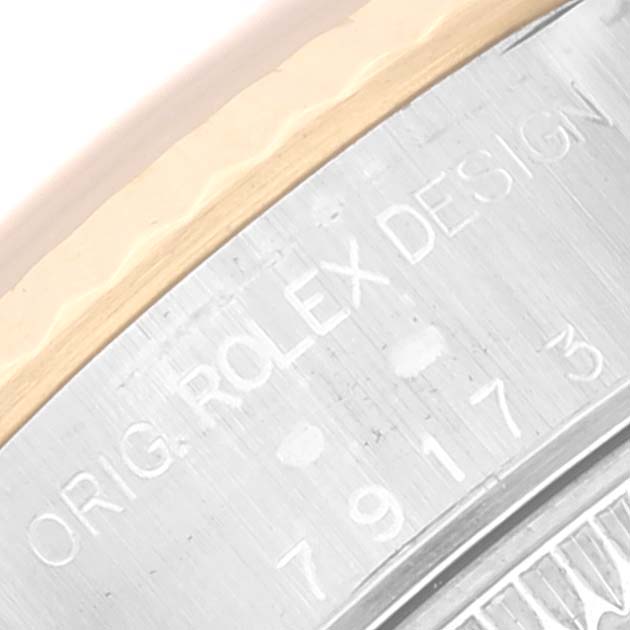 This close-up image shows the case side of a Rolex Datejust 79173 Women's Steel and Gold (two tone) Black Dial 79173 Women's Steel and Gold (two tone) Black Dial watch, focusing on the engraved model and serial numbers.