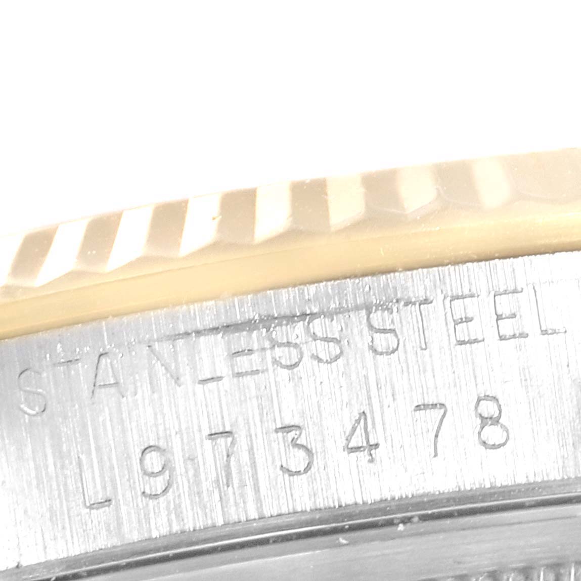 The image shows the side of the Rolex Datejust 16233 Men's Steel and Gold (two tone) Black Dial 16233 Men's Steel and Gold (two tone) Black Dial watch, highlighting its bezel and stainless steel case with serial number.