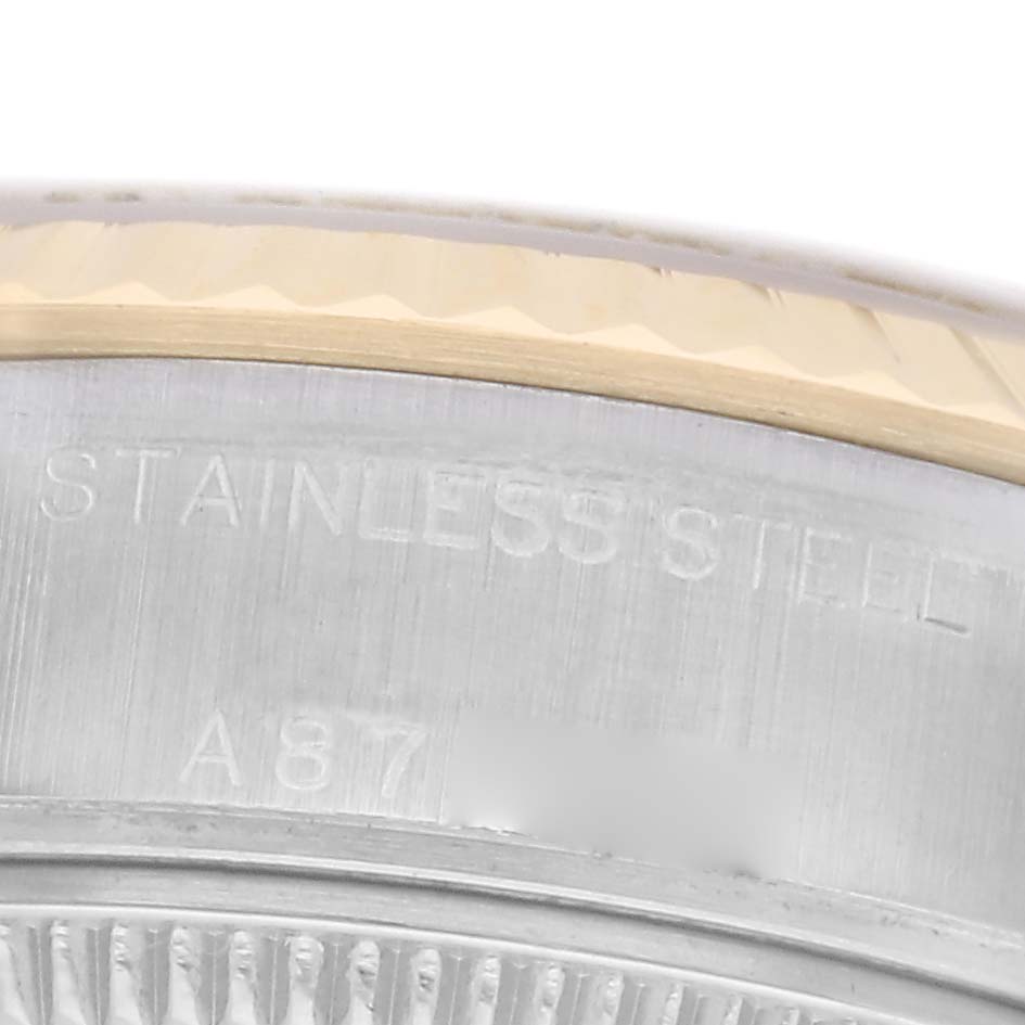 The image shows a close-up of the edge of a Rolex Datejust 79173 Women
s Steel and Gold (two tone) Champagne Dial 79173 Women
s Steel and Gold (two tone) Champagne Dial, highlighting the stainless steel case back with etched text.