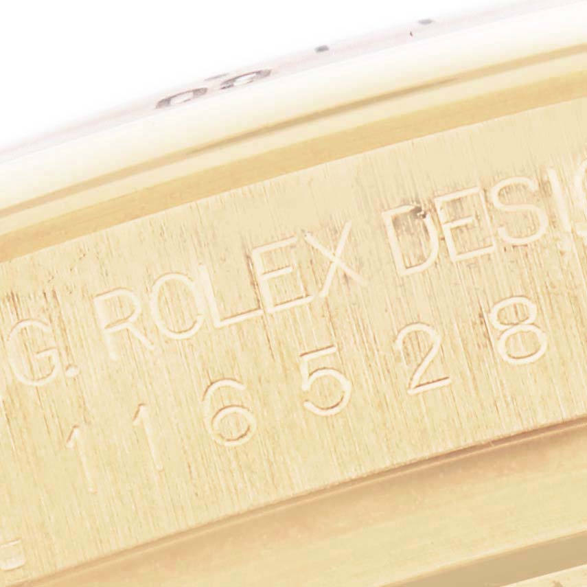 The image shows a close-up of the side of a Rolex Daytona 116528 Men
s Yellow Gold White Dial 116528 Men
s Yellow Gold White Dial with engravings, focusing on the model number.