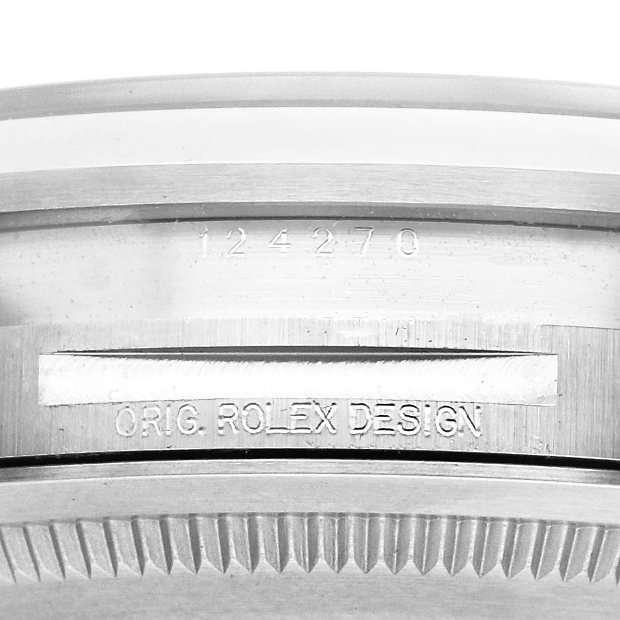 The image shows a close-up of the side of the bezel and case of a Rolex Explorer 124270 Men
s Stainless Steel Black Dial 124270 Men
s Stainless Steel Black Dial, highlighting its model number and "Orig. Rolex Design" engraving.