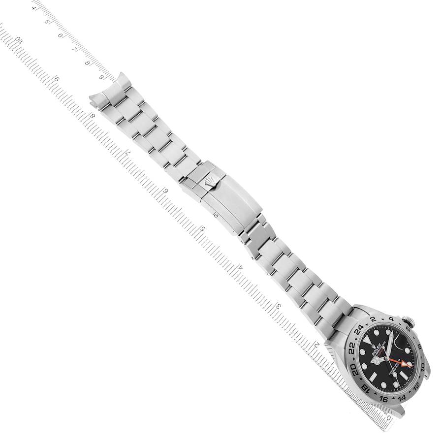 The Rolex Explorer 226570 Men's Stainless Steel Black Dial 226570 Men's Stainless Steel Black Dial watch is shown at an angle, displaying the face, bezel, and full stainless steel bracelet alongside a ruler.