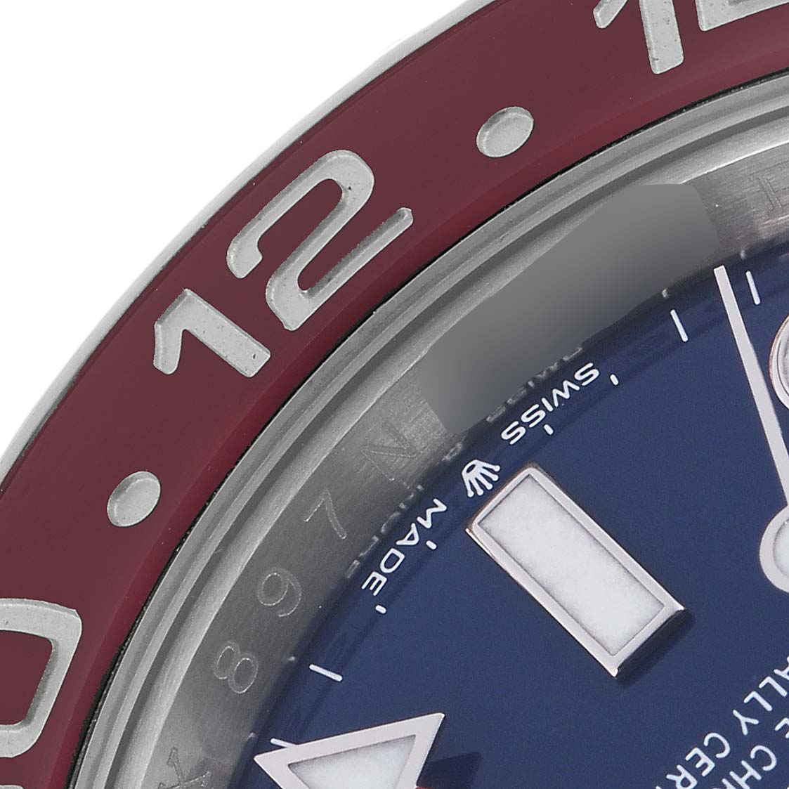 The image shows a close-up of the Rolex GMT-Master 126719 Men
s White Gold Blue Dial 126719 Men
s White Gold Blue Dial watch
s bezel and part of the dial, highlighting the 12 marker and "Swiss Made" text.