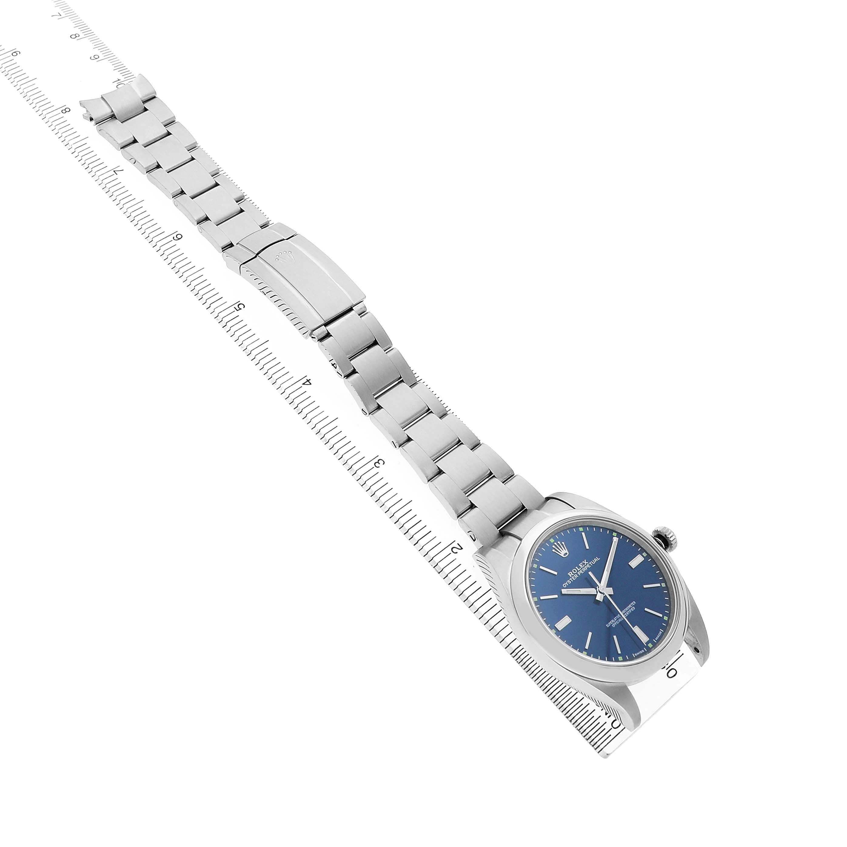 The Rolex Oyster Perpetual 114300 Men's Stainless Steel Blue Dial watch is shown at an angled view, highlighting the face, bracelet, and clasp.
