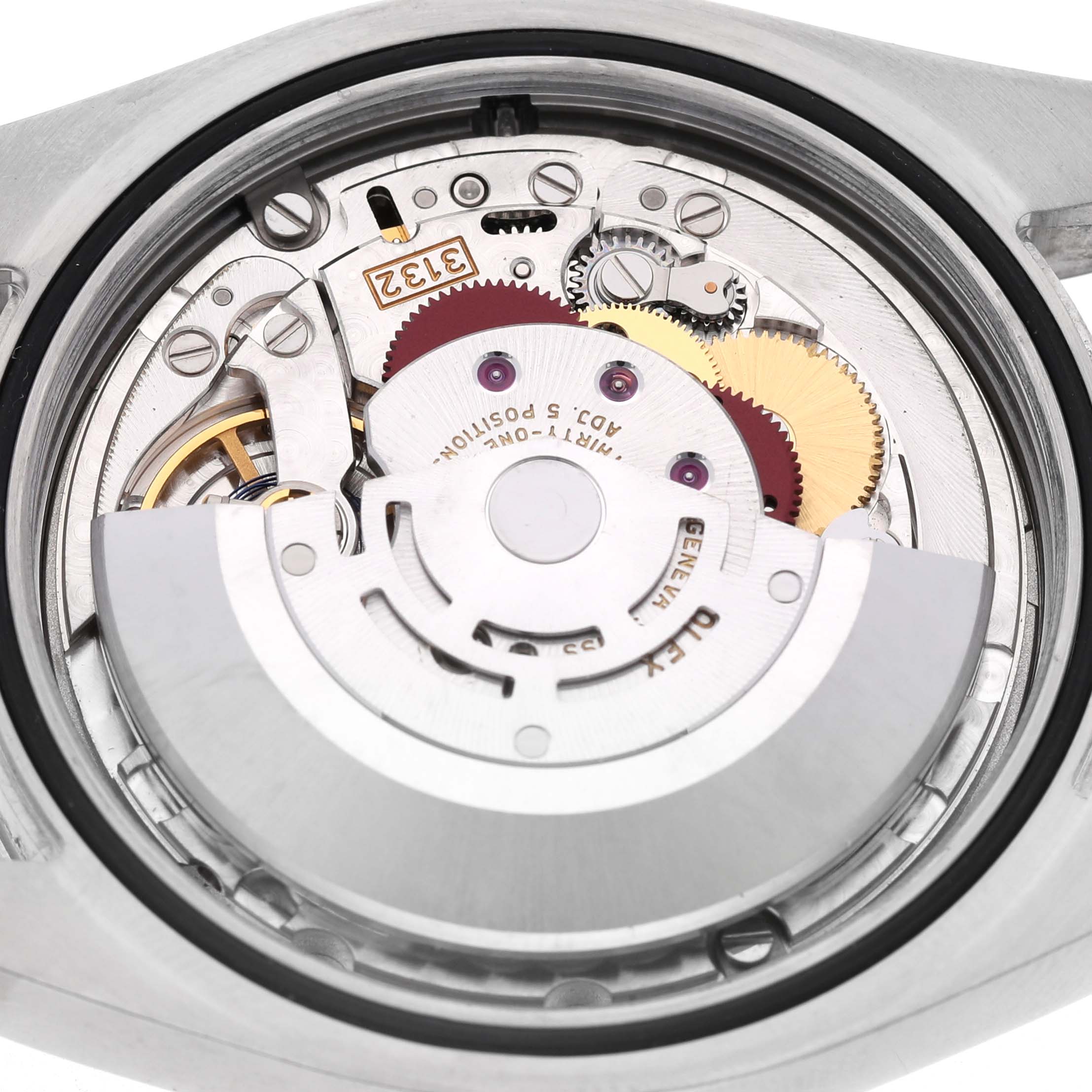 The image shows the movement of a Rolex Oyster Perpetual 114300 Men's Stainless Steel Blue Dial, highlighting gears and the rotor from the back.
