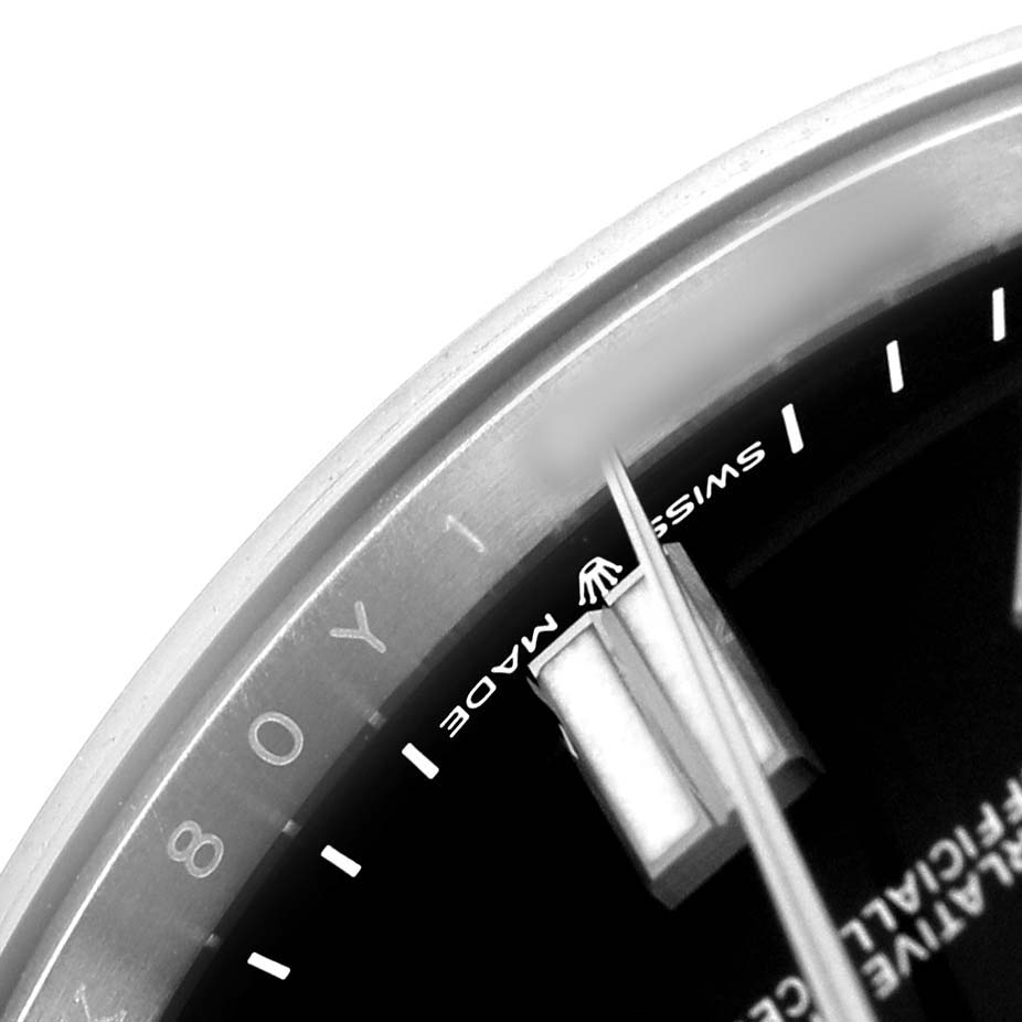 The image shows a close-up of the dial and hands of a Rolex Oyster Perpetual M124300-0002 Men's Stainless Steel Black Dial watch, focusing on the "Swiss Made" text.
