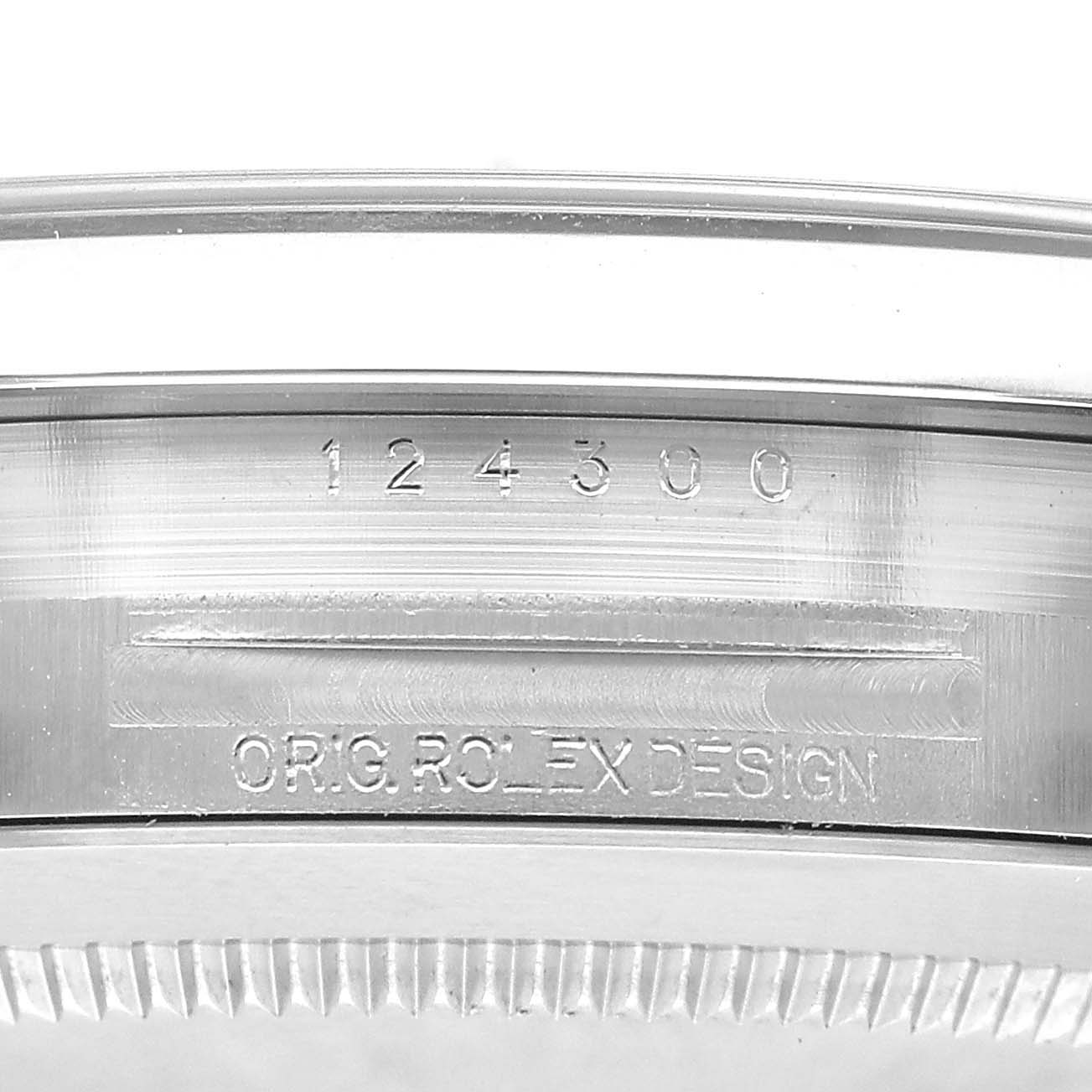 The image shows a close-up of the model number and design engraving on the case edge of a Rolex Oyster Perpetual M124300-0002 Men's Stainless Steel Black Dial watch.