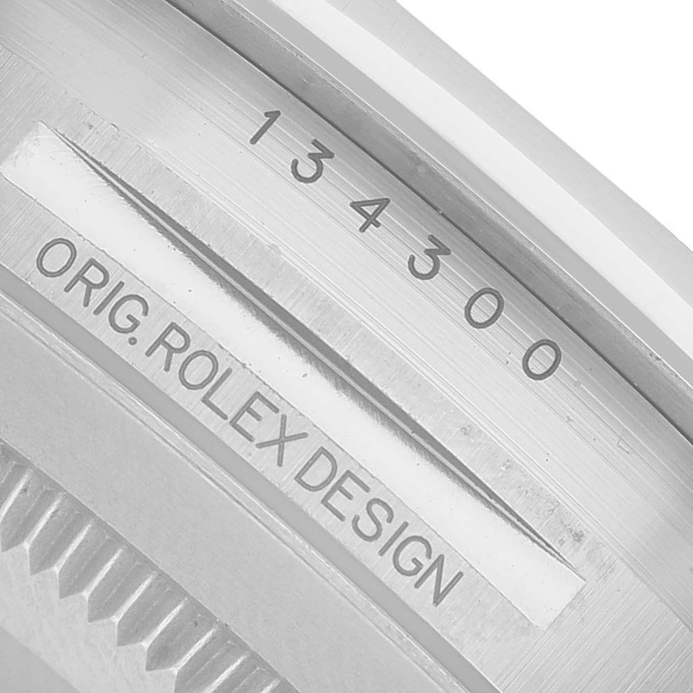 The image shows the serial number and design engraving on the side of the Rolex Oyster Perpetual 134300 Men's Stainless Steel Green Dial case.