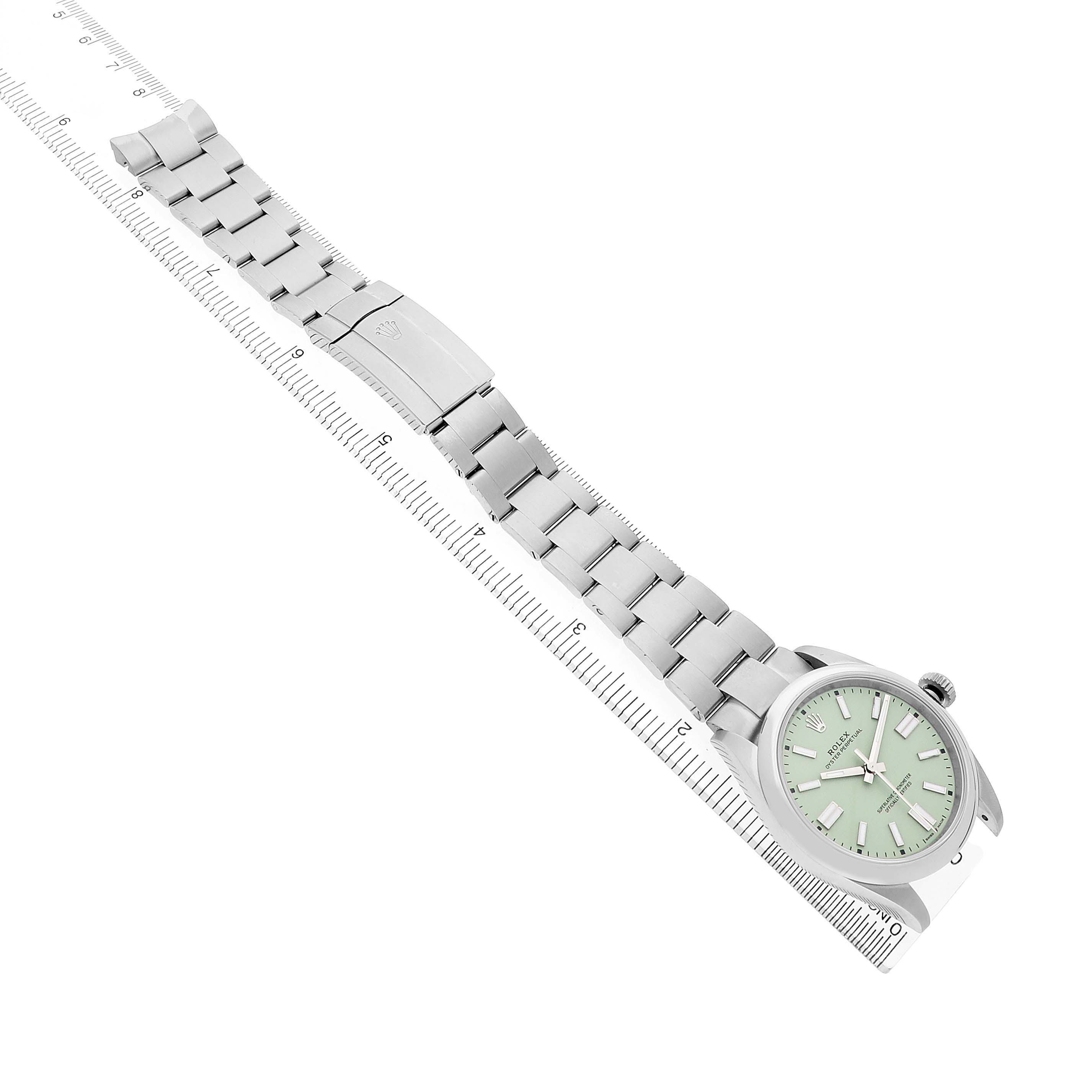 The image shows a top-down view of the Rolex Oyster Perpetual 134300 Men's Stainless Steel Green Dial watch, displaying the bracelet, clasp, dial, and case.