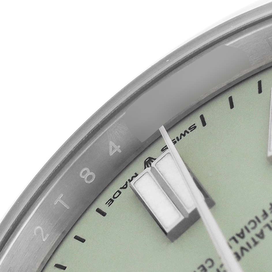The image shows a close-up angle of the dial, hands, and part of the bezel of a Rolex Oyster Perpetual 134300 Men's Stainless Steel Green Dial watch.