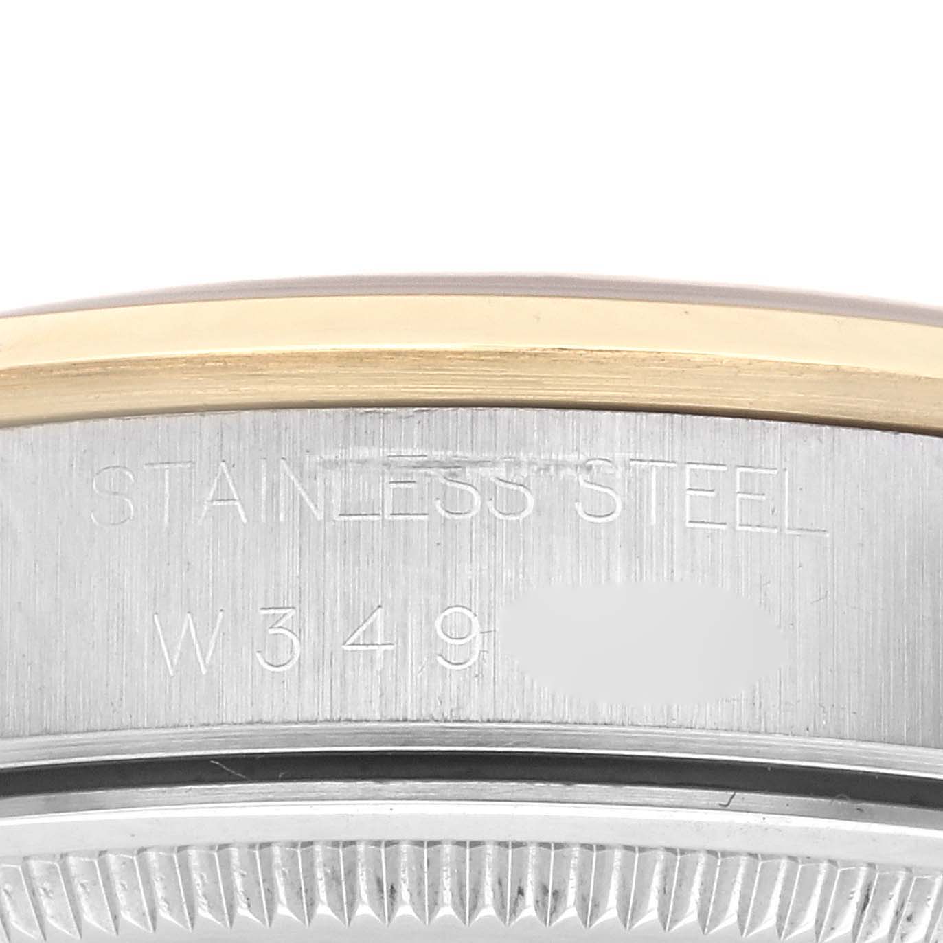 The image shows a close-up of the rim and engraved stainless steel side of a Rolex Oyster Perpetual 14203 Men's Steel and Gold (two tone) Black Dial 14203 Men's Steel and Gold (two tone) Black Dial watch.