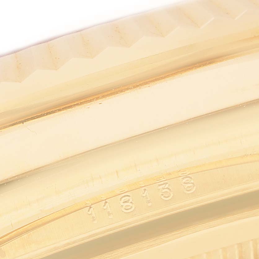 The image shows a close-up of the Rolex President 118138 Men's Yellow Gold Orange Dial model's bezel and engraved serial number from a side angle.