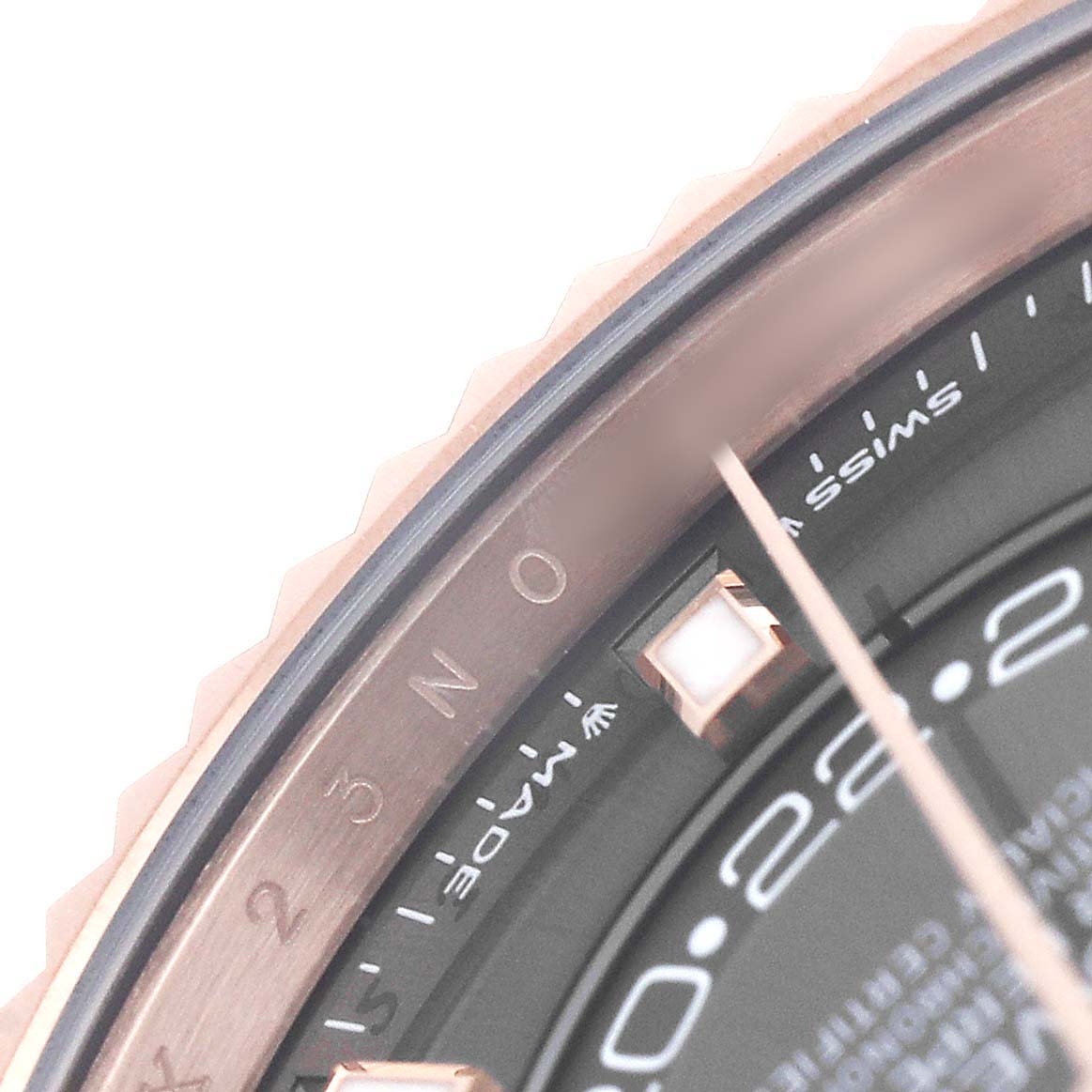 The image shows a close-up of the bezel and a portion of the dial on a Rolex Sky-Dweller 336935 Men's Rose Gold Grey Dial.