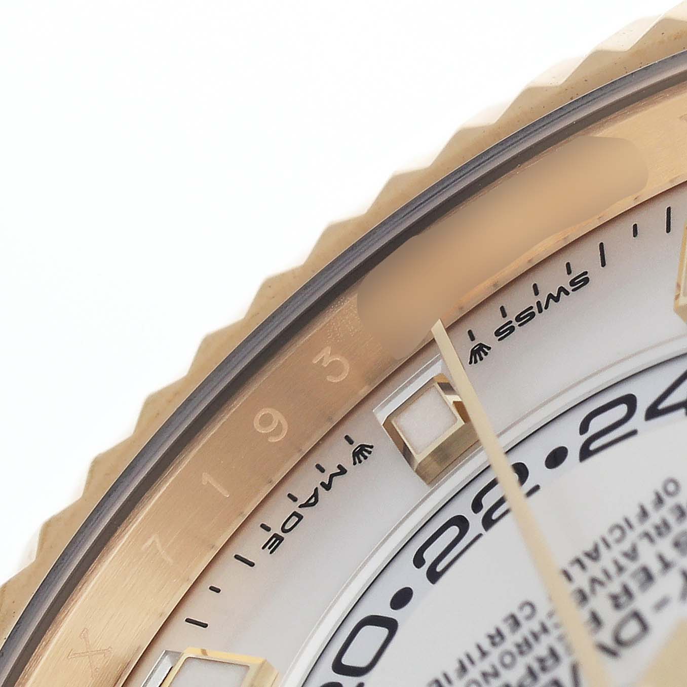 The image shows a close-up of the bezel, part of the dial, and markers of a Rolex Sky-Dweller 336938 Men's Yellow Gold White Dial watch.