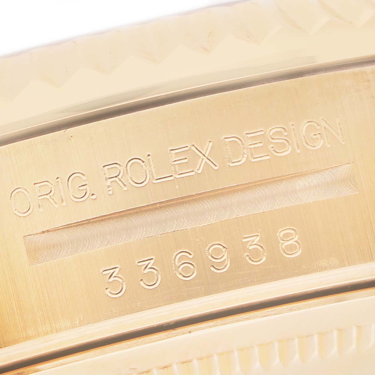 The image shows a close-up of the side engraving on a Rolex Sky-Dweller 336938 Men's Yellow Gold White Dial watch, highlighting the model and serial number.