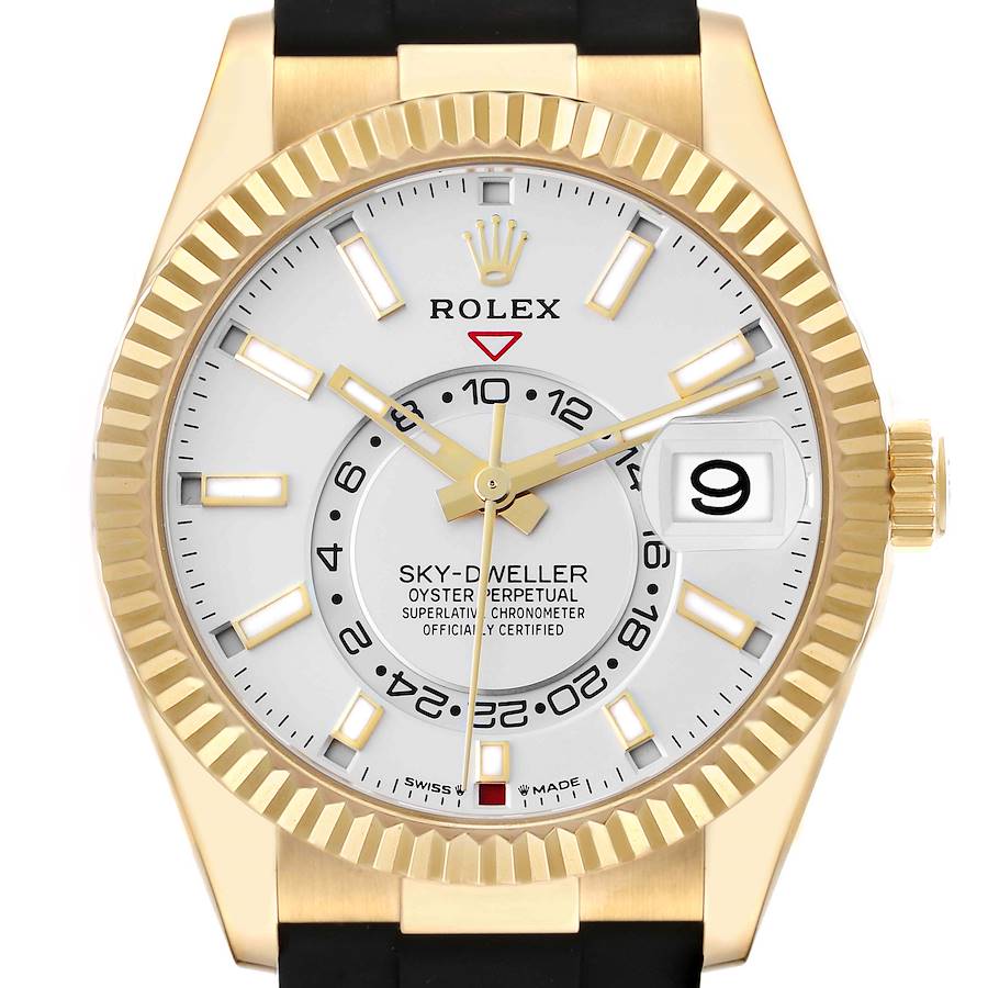 The Rolex Sky-Dweller is shown from a front angle, highlighting its gold case, fluted bezel, white dial, and Oysterflex bracelet.