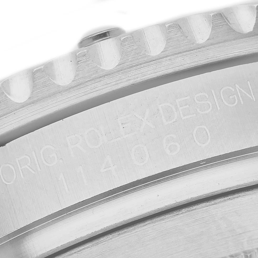 The image shows an angled close-up of the Rolex Submariner 114060 Men's Stainless Steel Black Dial's case side, featuring engraved model details.