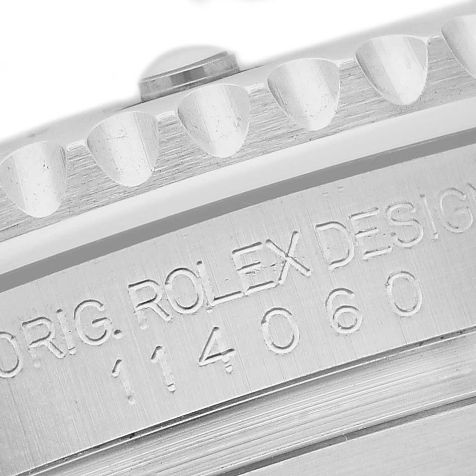 The image shows a close-up of the edge and engraved serial number on the case of a Rolex Submariner 114060 Men's Stainless Steel Black Dial watch.