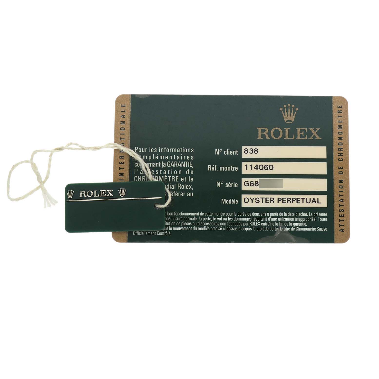 The image shows a warranty card and a green Rolex tag for a Rolex Submariner 114060 Men's Stainless Steel Black Dial model.