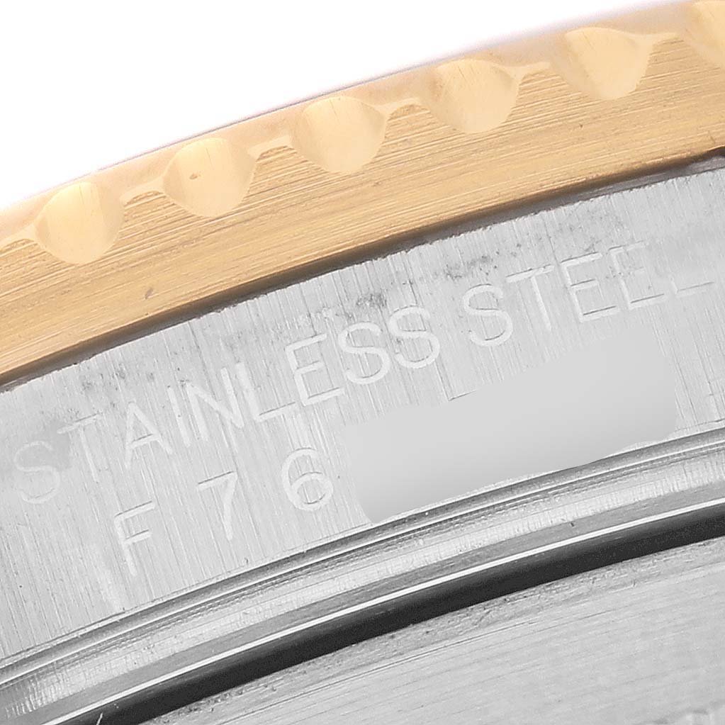 The image shows a close-up of the Rolex Submariner 16613 Men's Steel and Gold (two tone) Blue Dial's steel and gold bezel edge, revealing the model's engravings.