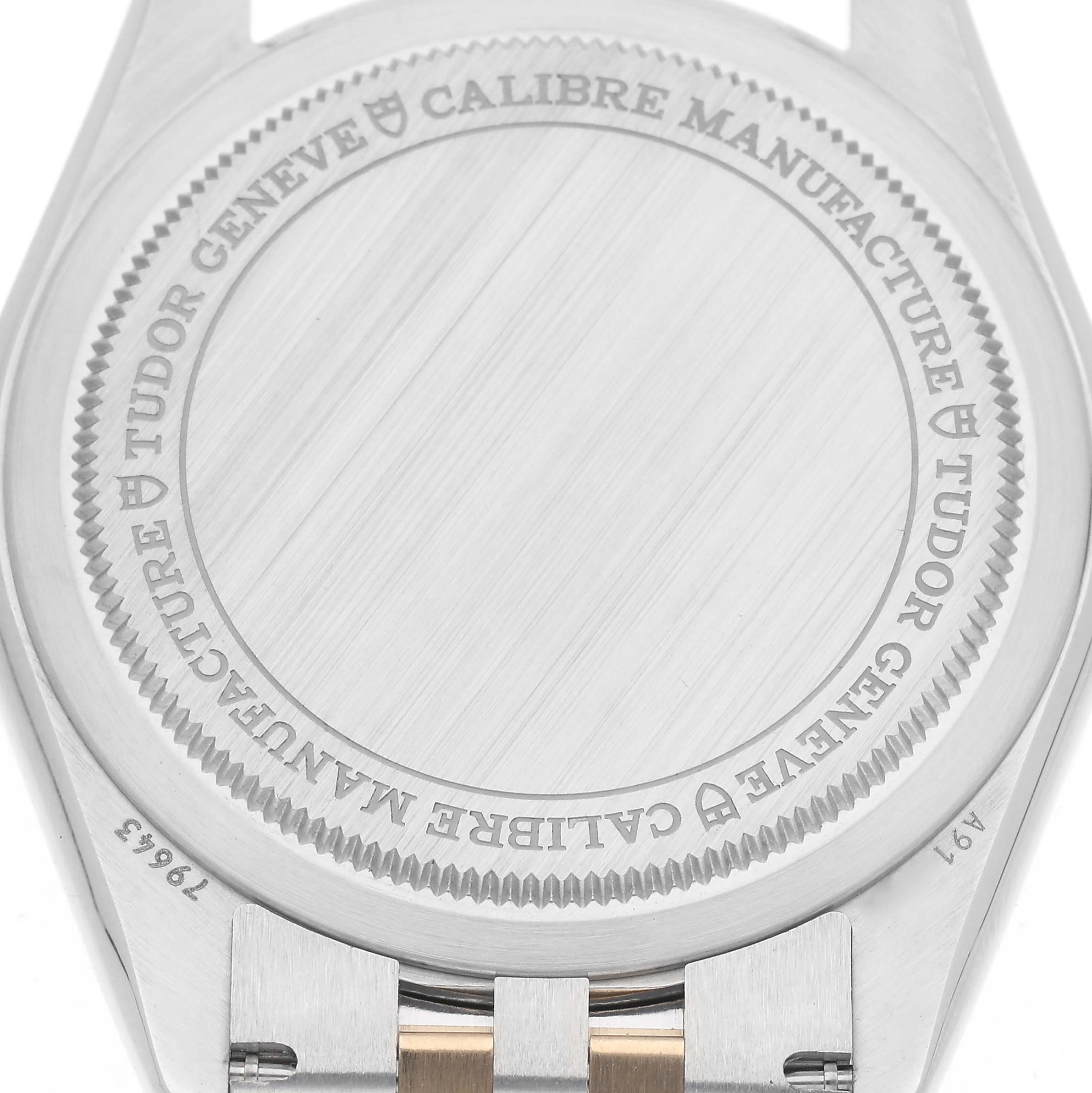 The image shows the back case of a Tudor Heritage Black Bay M79643-0005 Men
s Steel and Gold (two tone) Champagne Dial M79643-0005 Men
s Steel and Gold (two tone) Champagne Dial watch, highlighting the engraved text and part of the bracelet.