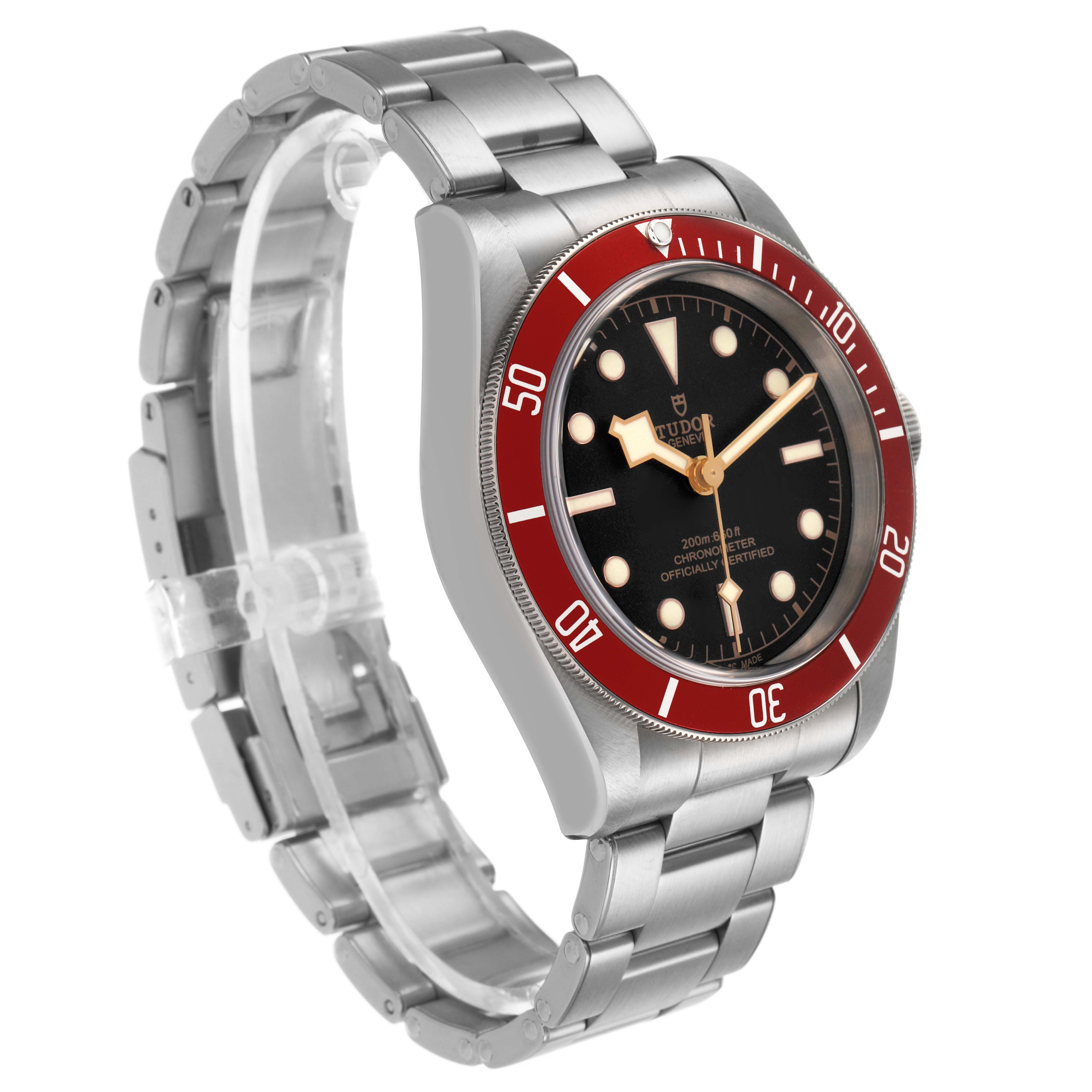 The Tudor Heritage Black Bay 79230R Men's Stainless Steel Black Dial watch is shown at a slight angle displaying its face, red bezel, and metal bracelet.