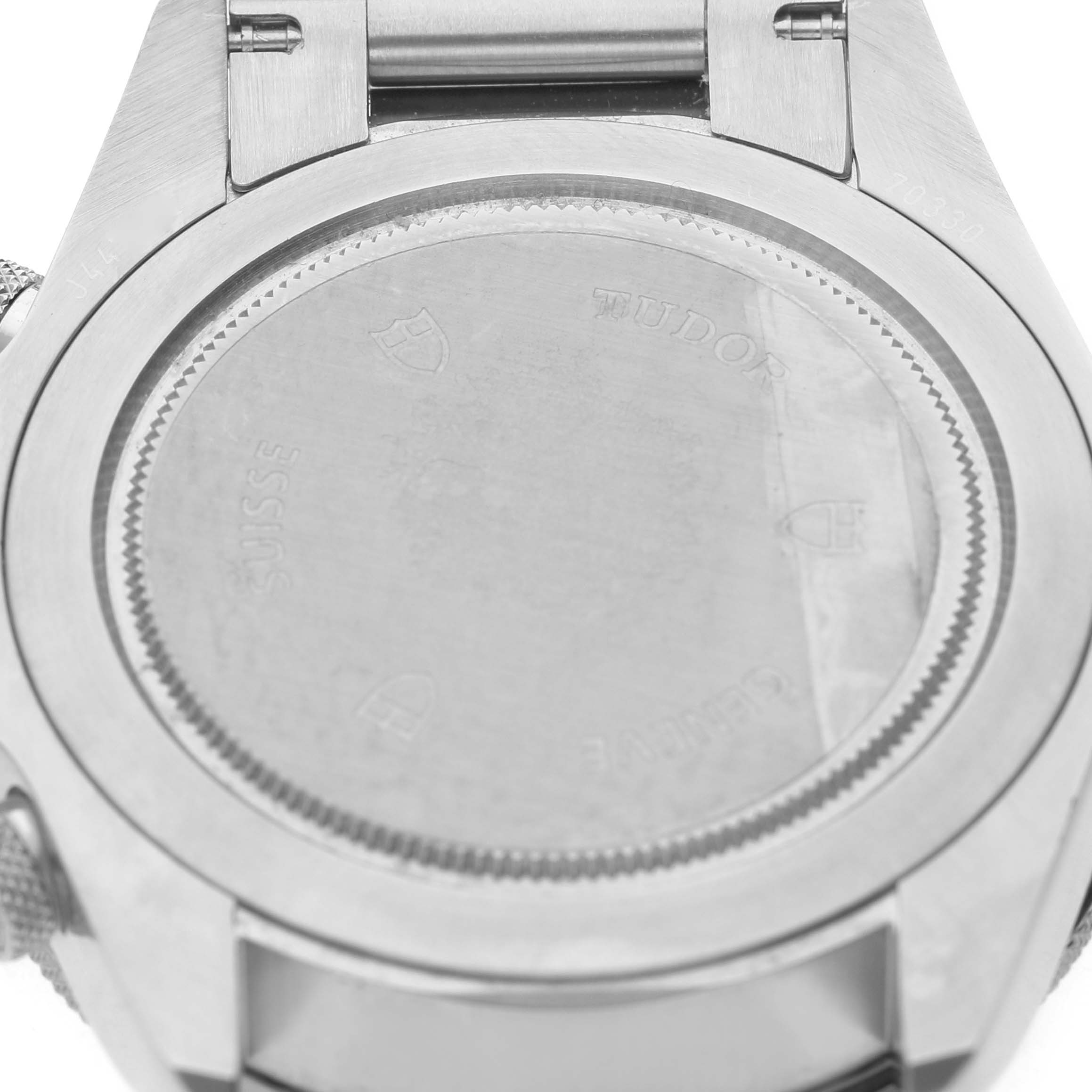 The image shows the case back of a Tudor Heritage Chrono 70330N Men's Stainless Steel Black Dial watch from a close-up angle.