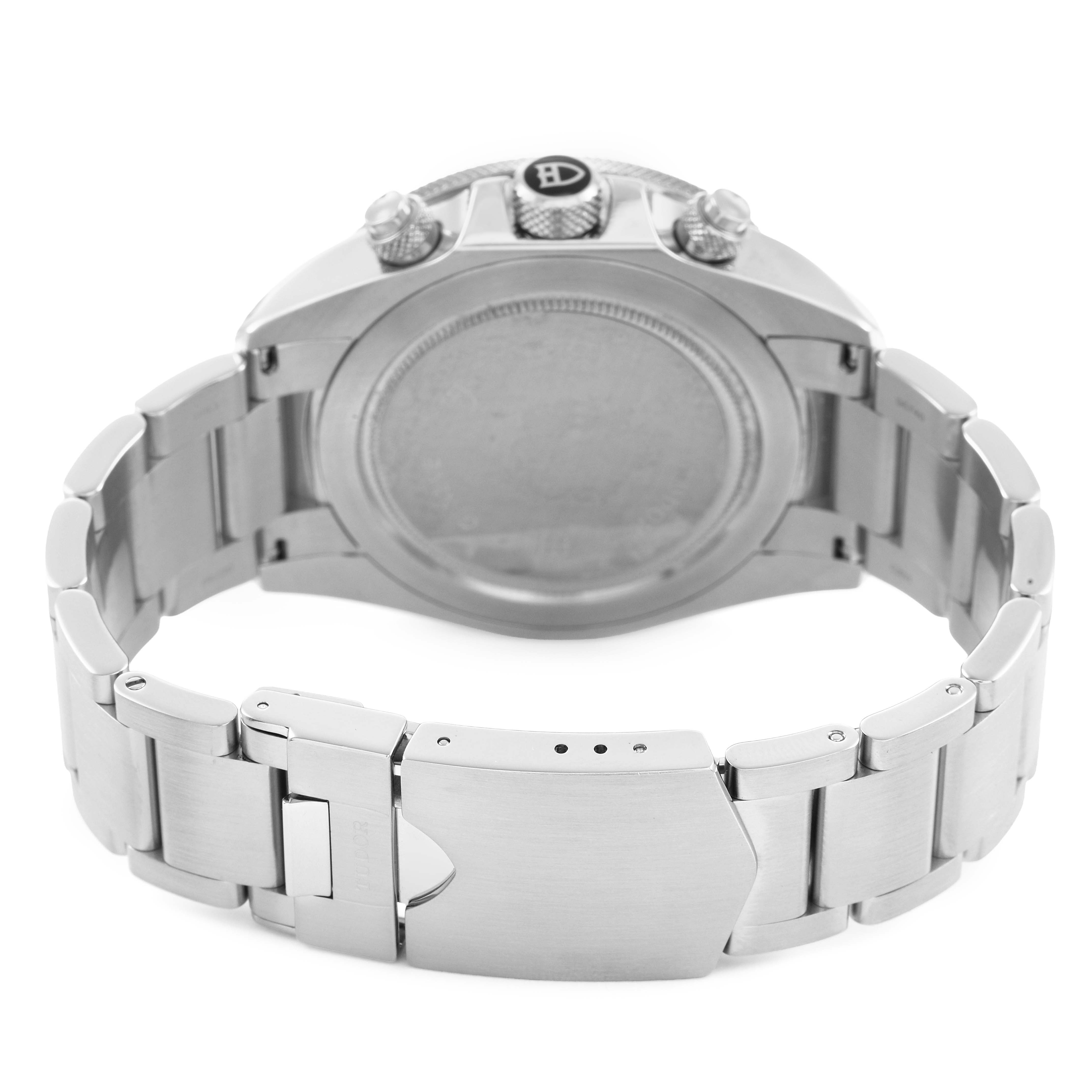 The image shows the back view of the Tudor Heritage Chrono 70330N Men's Stainless Steel Black Dial watch, highlighting the clasp, bracelet, and case back.