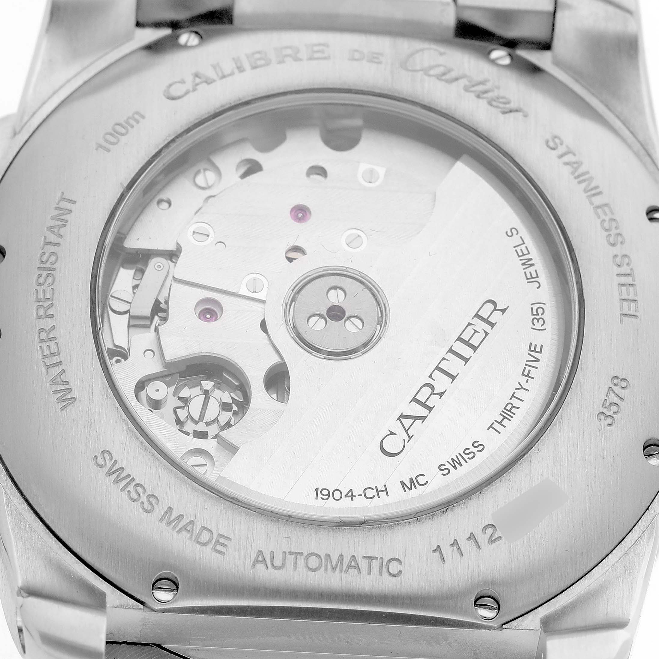 The image shows the back view of the Calibre de Cartier watch, displaying its automatic movement and inner mechanisms.