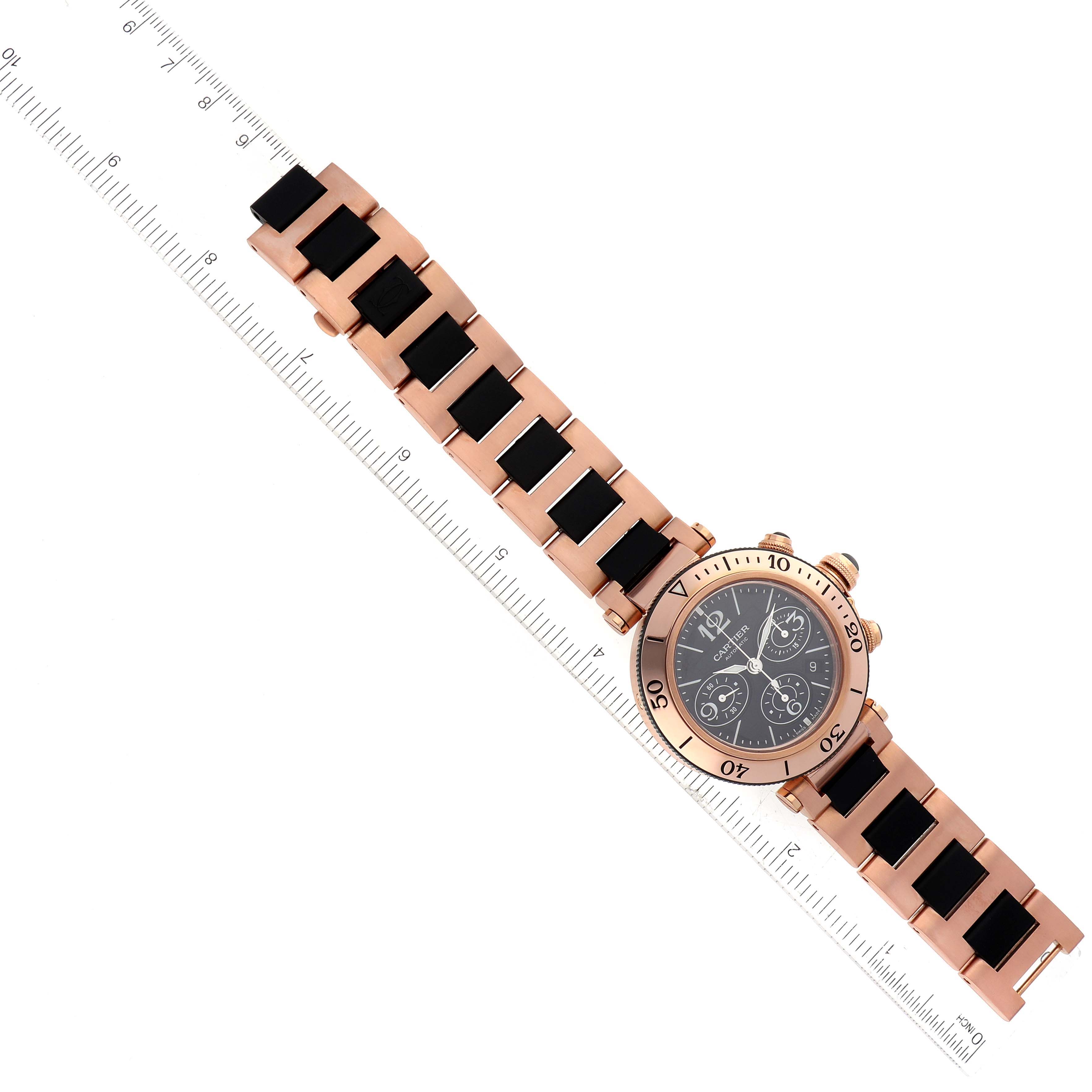The image shows a Cartier Pasha 63483 Men's Rose Gold Black Dial 63483 Men's Rose Gold Black Dial model watch laid flat with its strap and face fully visible, alongside a ruler for scale.