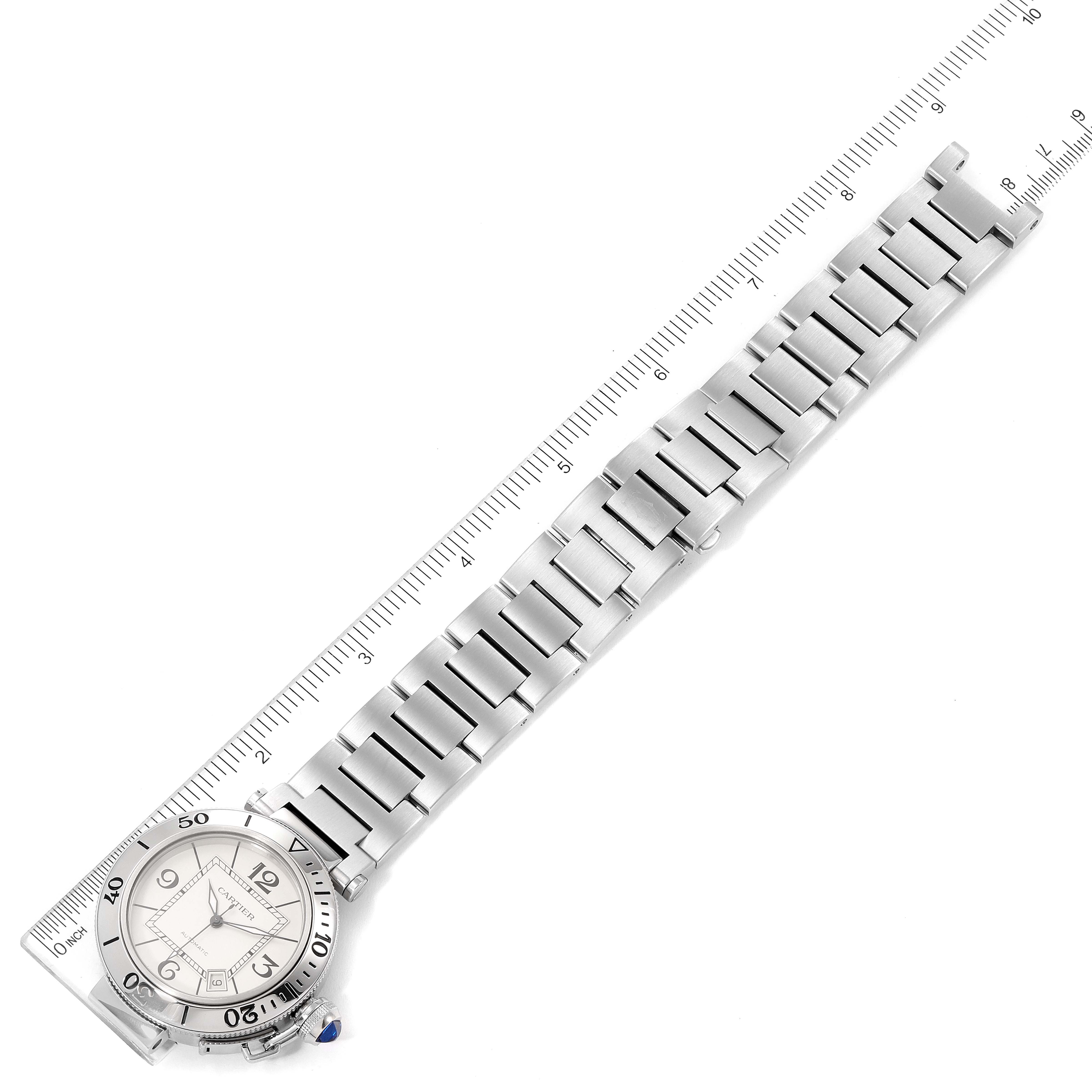 The image shows a top-down view of a Cartier Pasha W31080M7 Men
s Stainless Steel Silver Dial W31080M7 Men
s Stainless Steel Silver Dial watch with its full stainless steel band and a measuring scale.