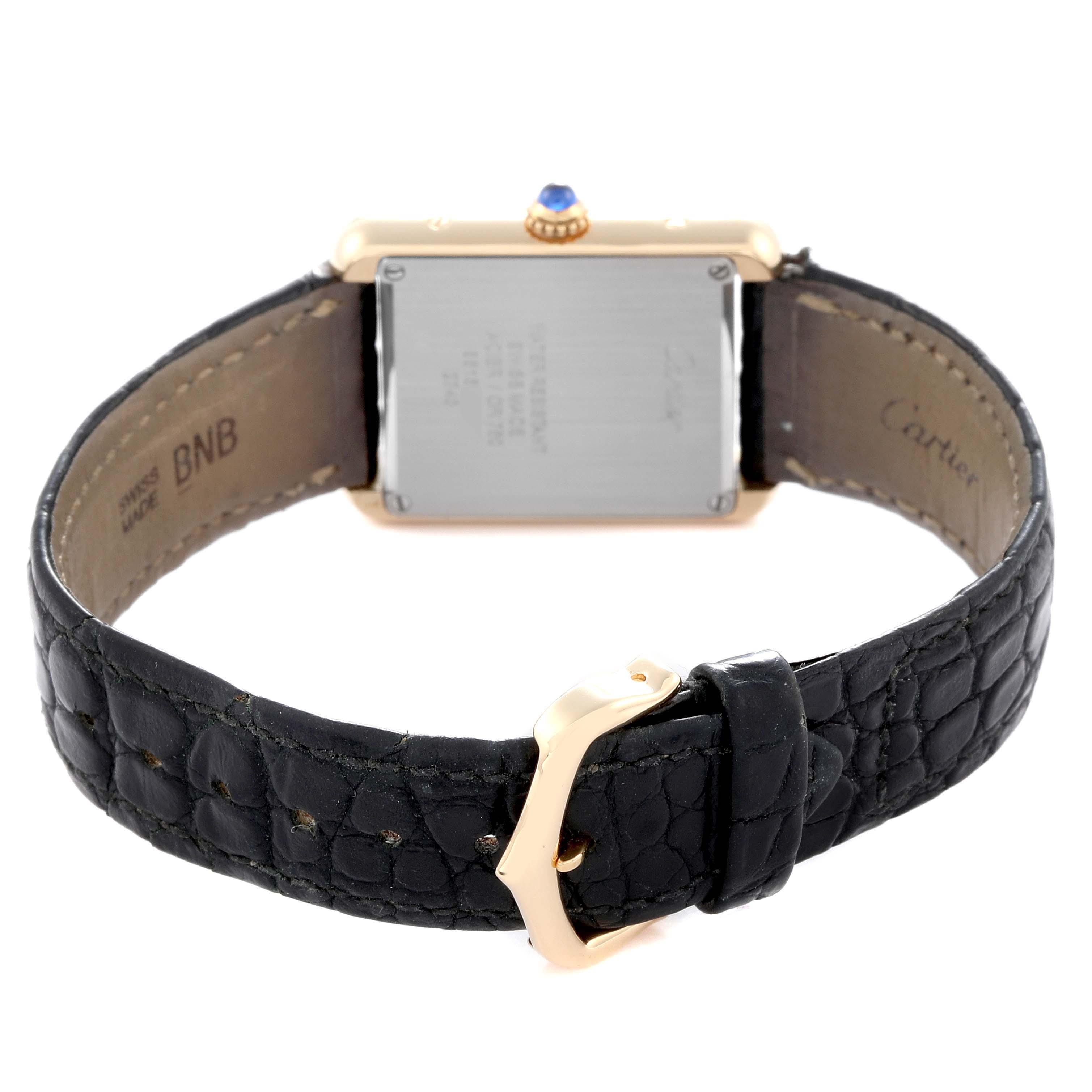 The image shows the back view of a Cartier Tank Solo watch, model number W1018755, highlighting the case back, strap, and clasp.