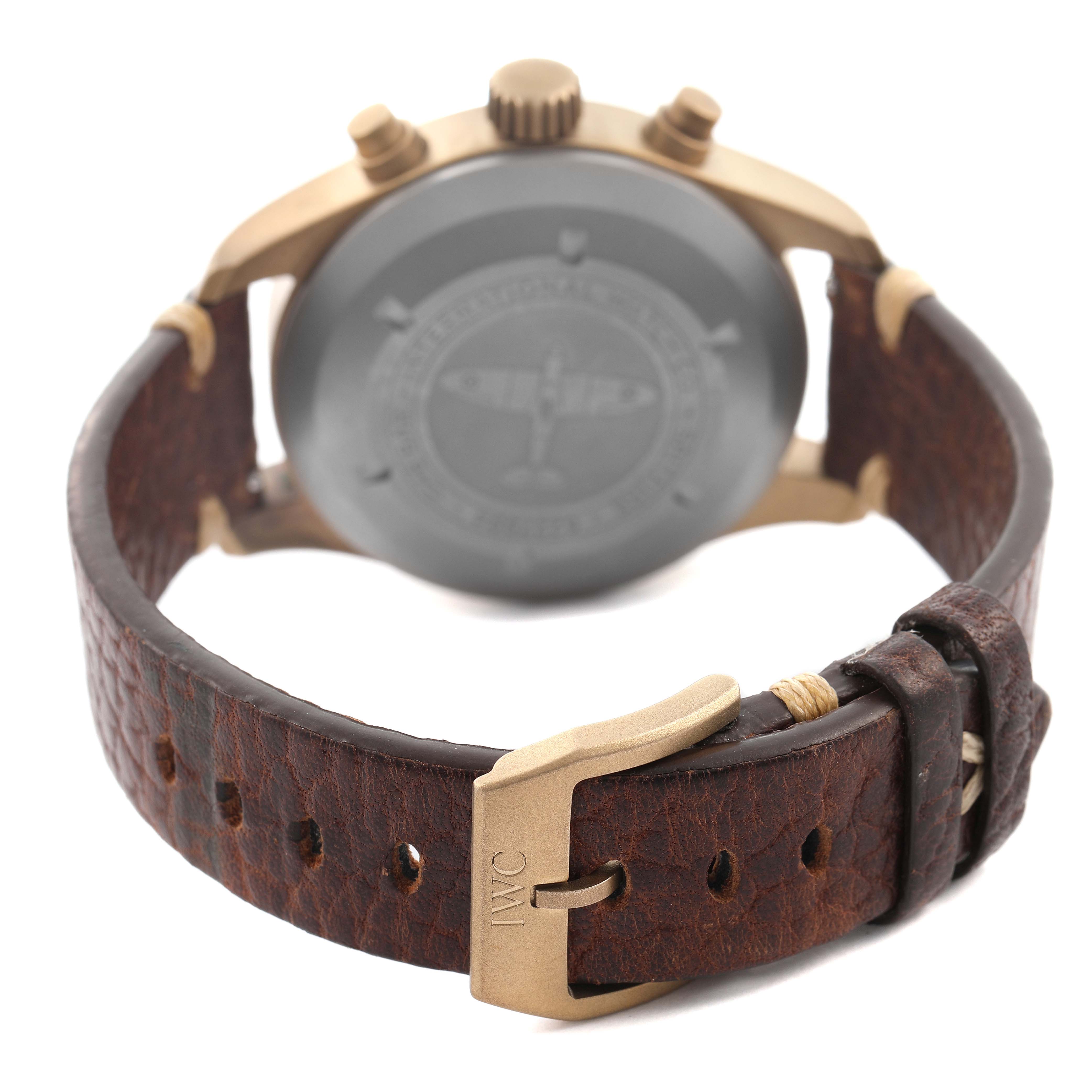 The IWC Pilot IW387902 Men's Bronze Green Dial watch is shown from the back, highlighting the case, strap, clasp, and pushers.
