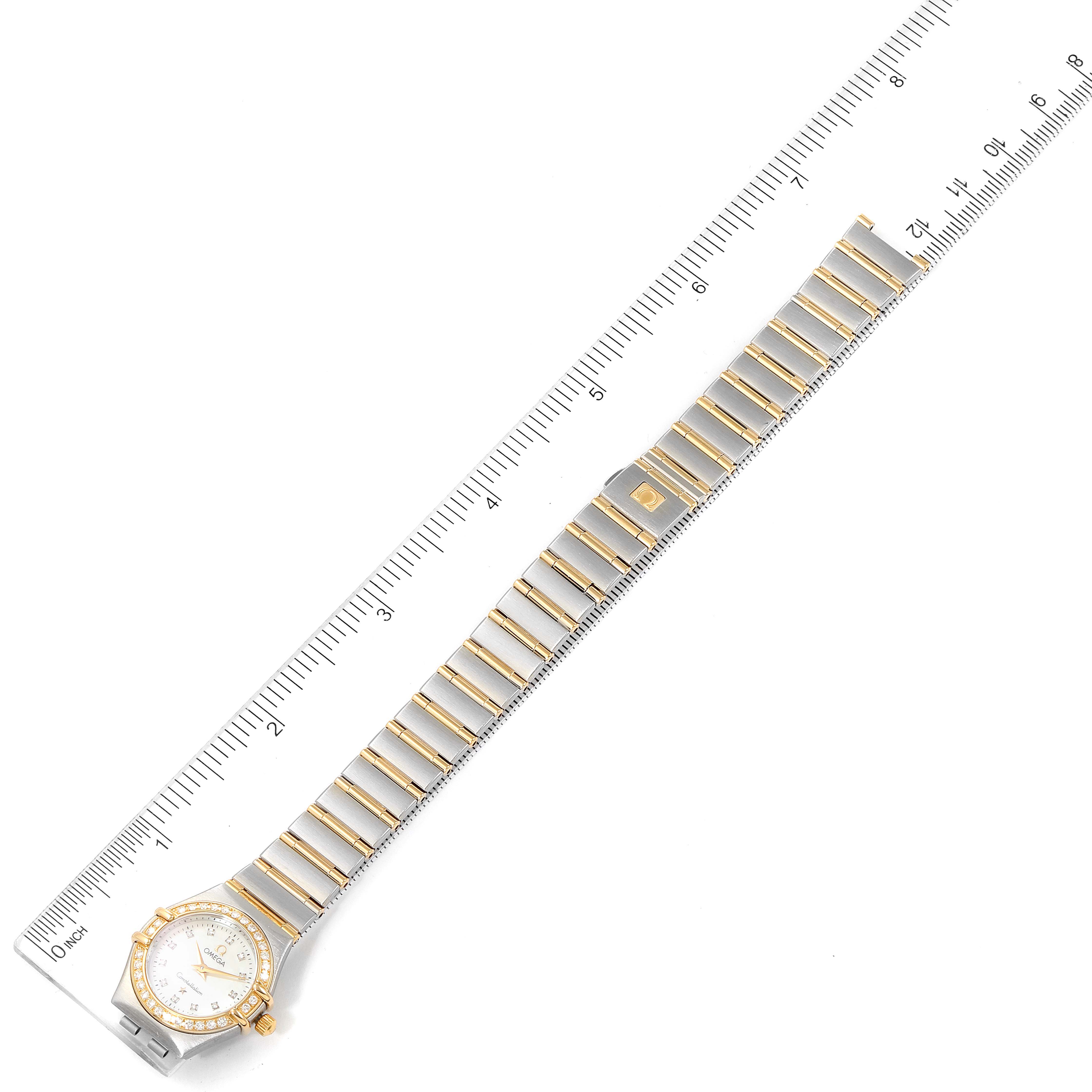 The image shows an Omega 1267.75.00 Women's Steel and Gold (two tone) Mother of Pearl Dial 1267.75.00 Women's Steel and Gold (two tone) Mother of Pearl Dial Constellation 95 Mother of Pearl Diamond Watch 1267.75.00 laid flat with a ruler for scale.