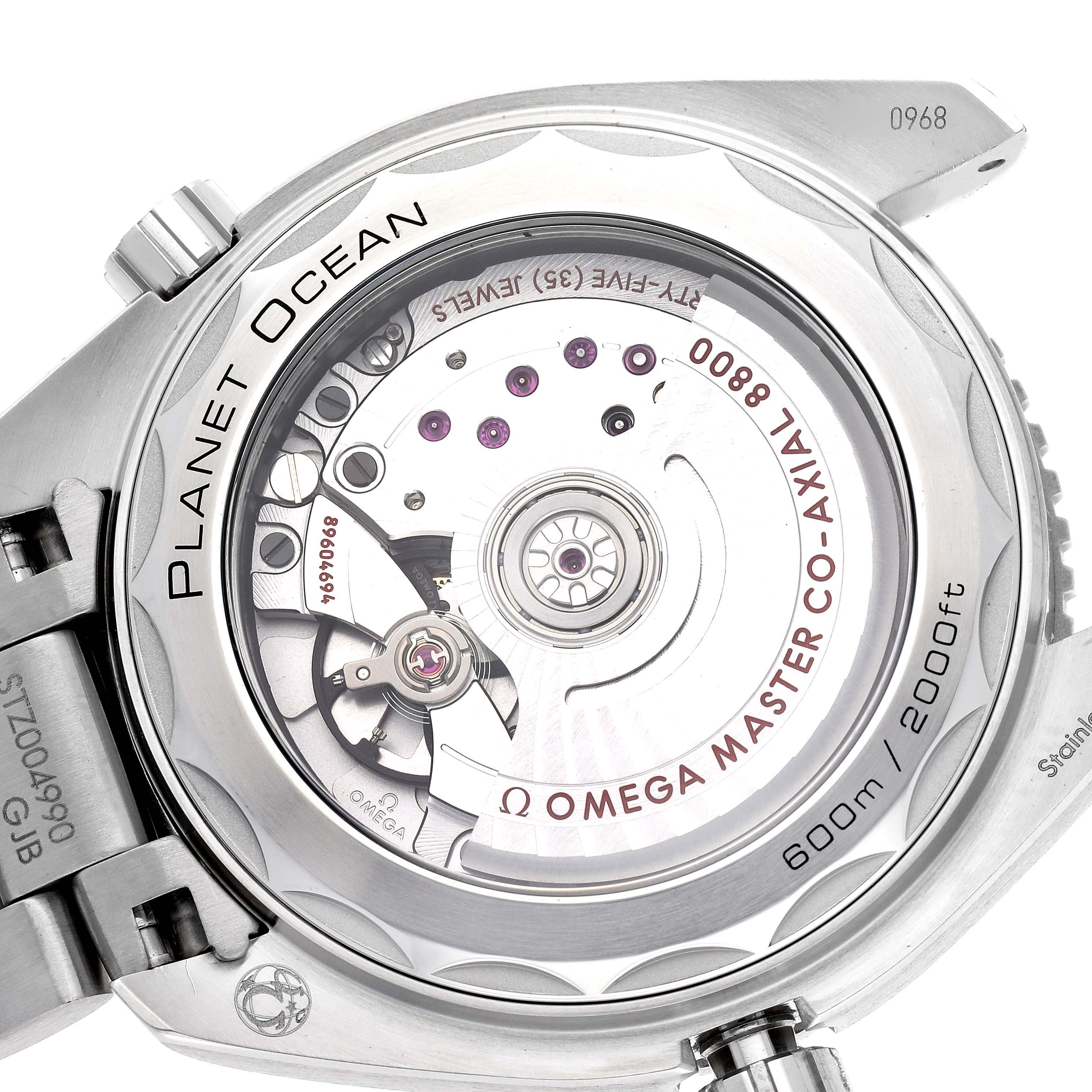 The image shows the back of the Omega Planet Ocean model 215.30.40.20.01.001, highlighting its co-axial movement and transparent case back.