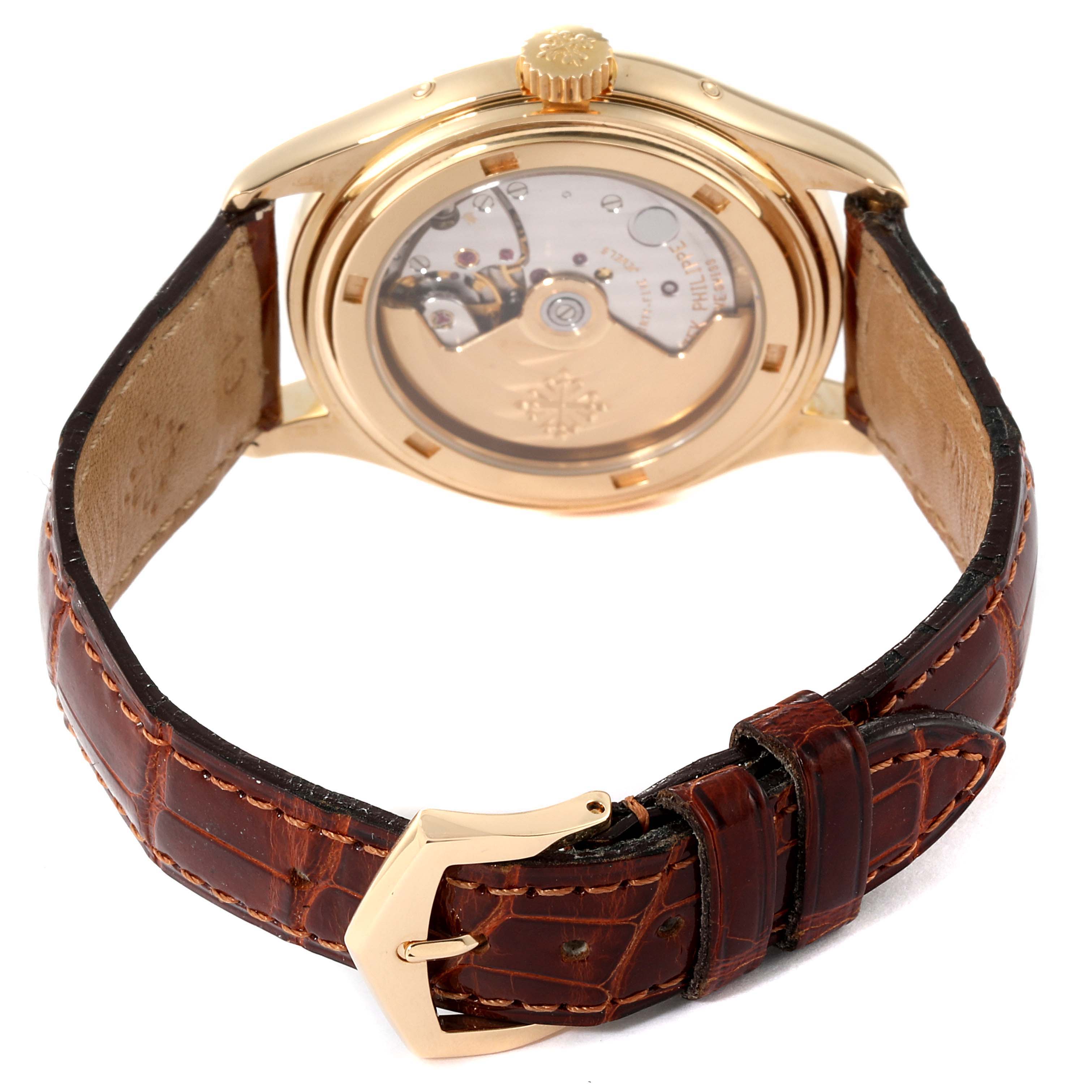 The image shows the back view of a Patek Philippe Complications 5035G Men's Yellow Gold Silver Dial 5035G Men's Yellow Gold Silver Dial watch, displaying its transparent case back and leather strap.