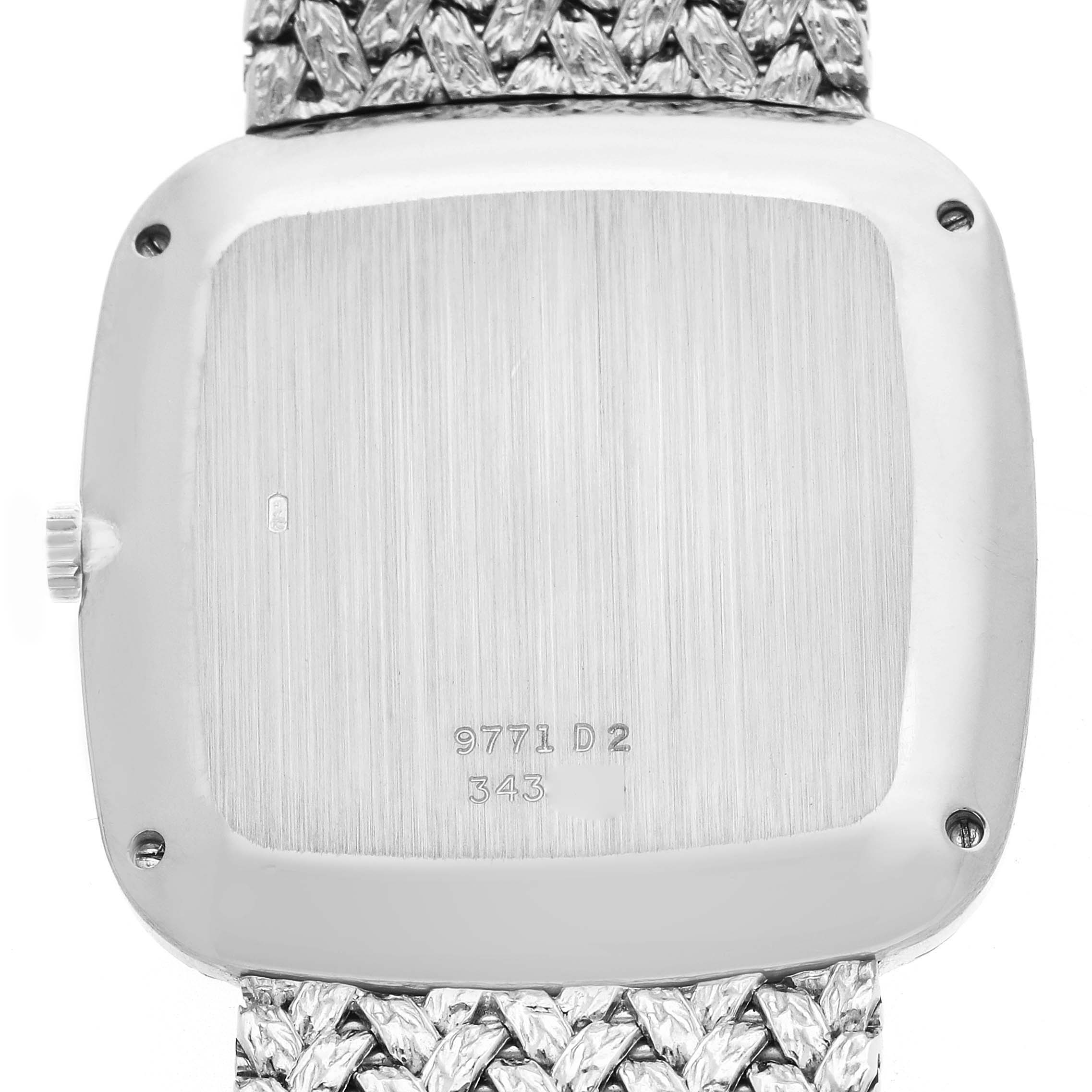 The image shows the back of a Piaget model 9771D2 men
s watch, highlighting its case back with inscriptions and a portion of the textured bracelet.