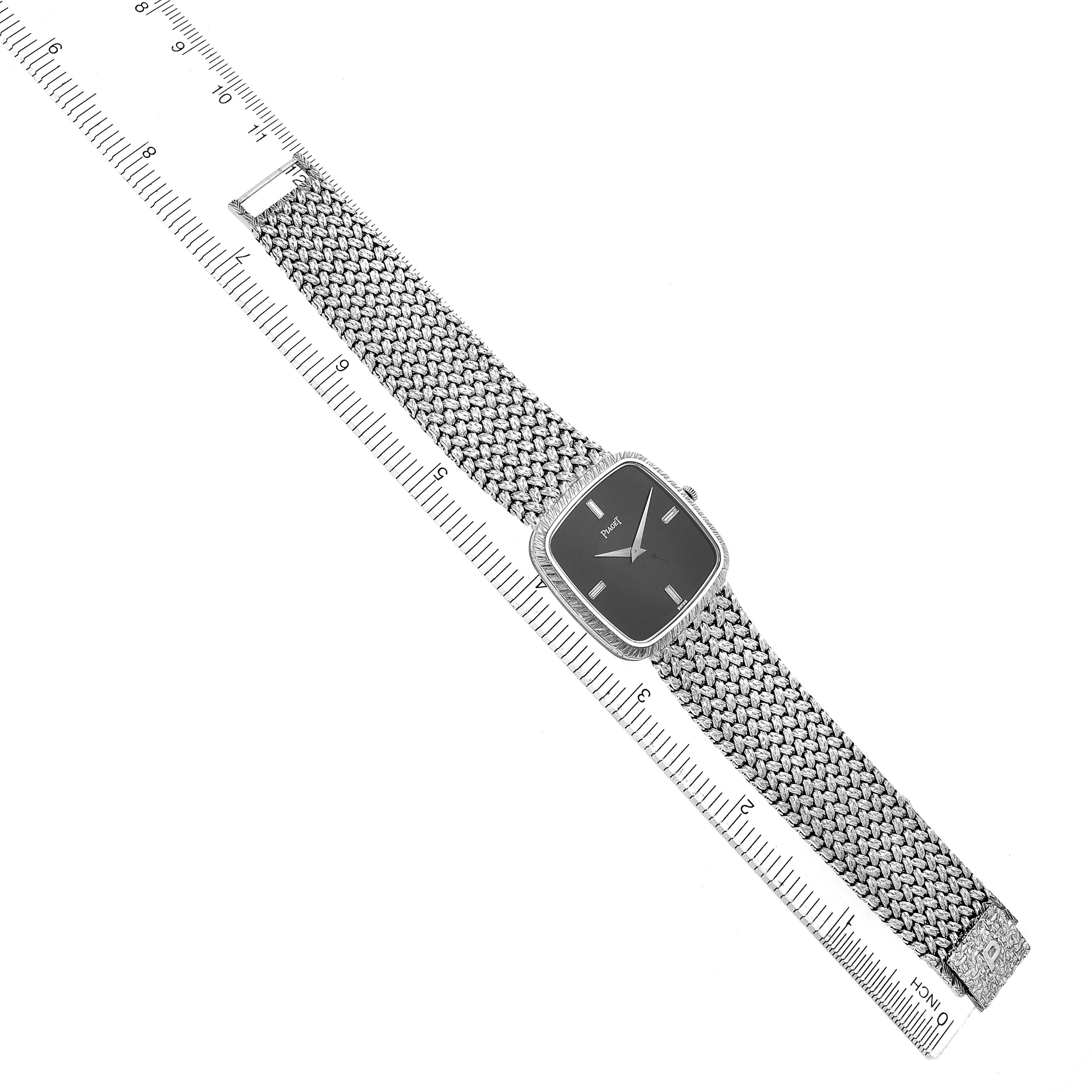 The Piaget 9771D2 men
s watch is displayed from a top-down angle, showing its full face and woven bracelet, with a ruler for size reference.