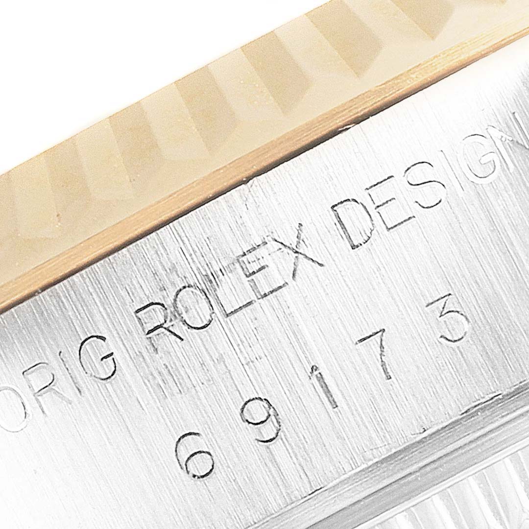 The image shows a close-up of the side of a Rolex Datejust 69173 Women's Steel and Gold (two tone) Blue Dial 69173 Women's Steel and Gold (two tone) Blue Dial model, focusing on the engraved text and part of the bezel.