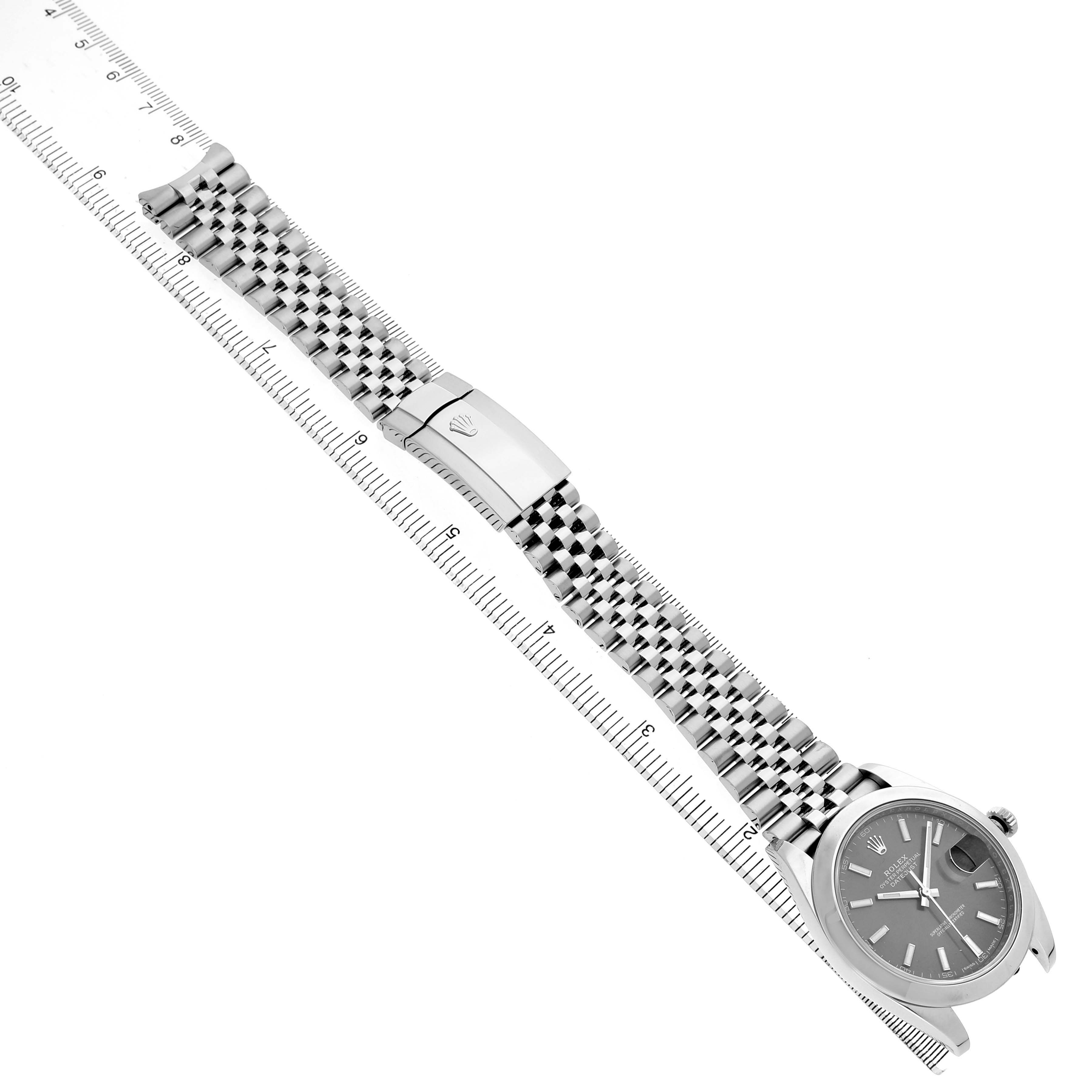 The Rolex Datejust 41 126300 Men's Stainless Steel Grey Dial watch is shown from a top view, displaying the face, bracelet, and clasp, with a measuring scale beside it.
