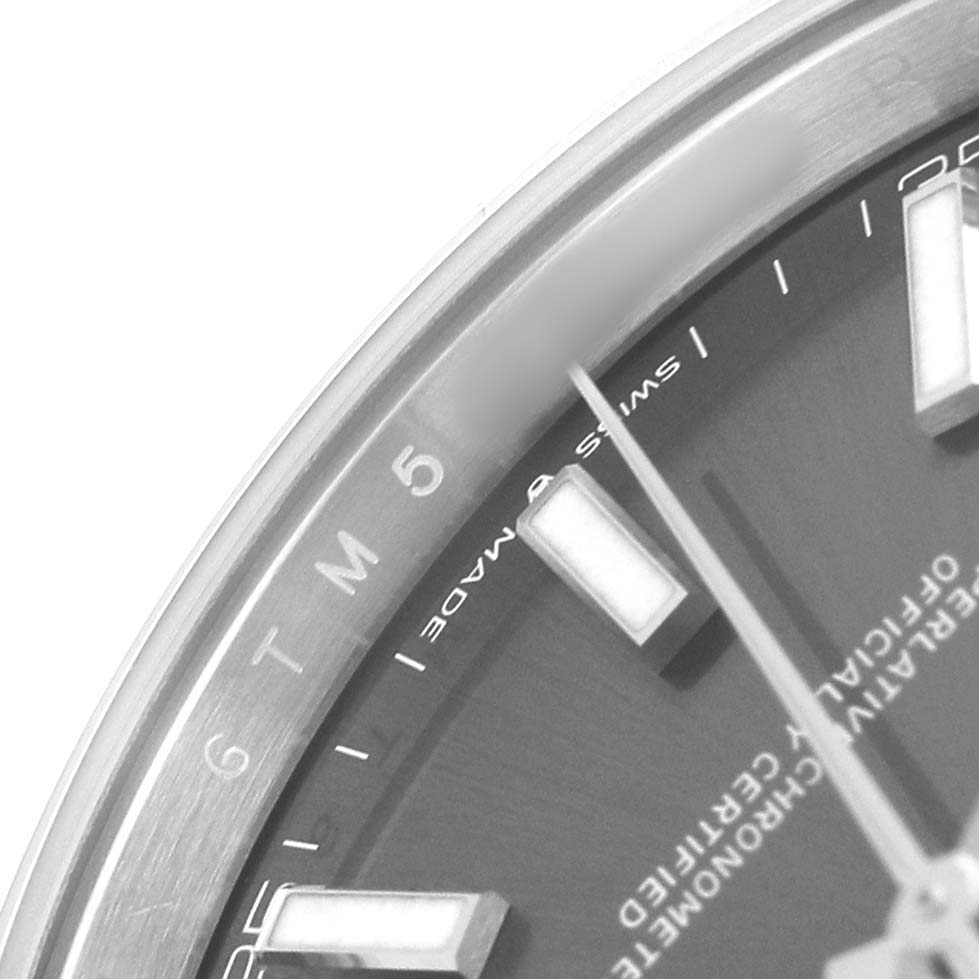 The image shows a close-up of the dial and part of the bezel of a Rolex Datejust 41 126300 Men's Stainless Steel Grey Dial, focusing on indices and text details.