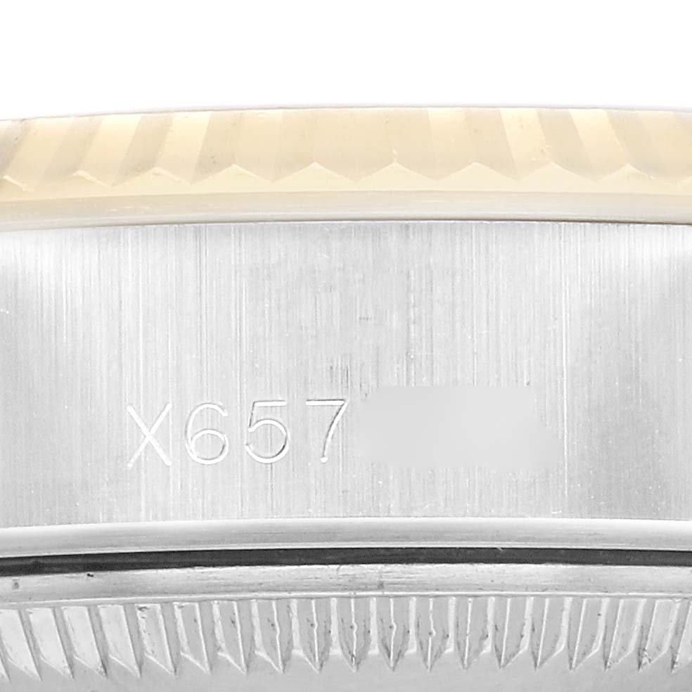 The image shows a close-up of the side of a Rolex Datejust model 69173, focusing on the case with visible engravings and the edge of the bezel.