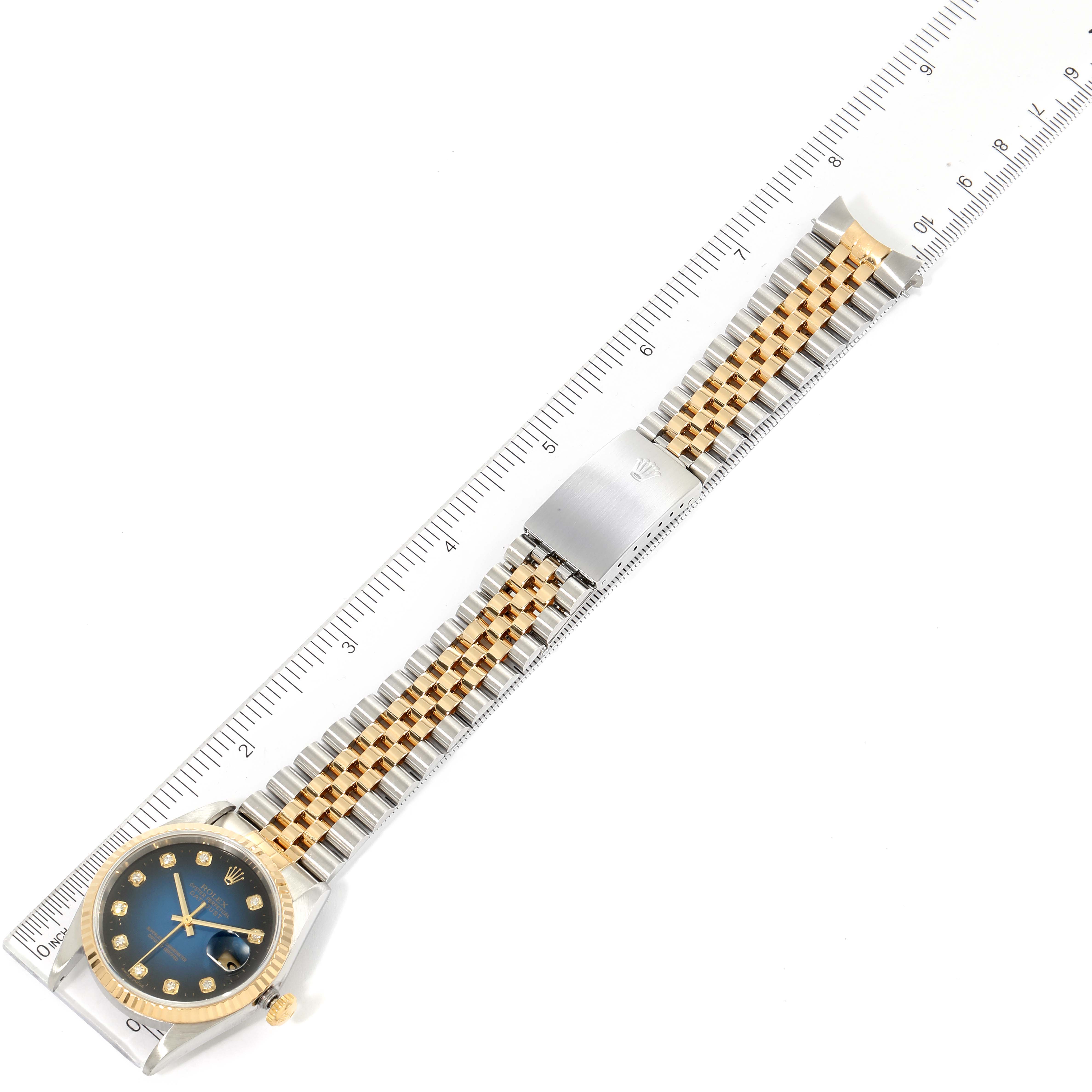 The image shows a top-down view of a Rolex Datejust 16233 Men's Steel and Gold (two tone) Blue Dial 16233 Men's Steel and Gold (two tone) Blue Dial watch, highlighting the dial, bezel, and bracelet against a ruler.