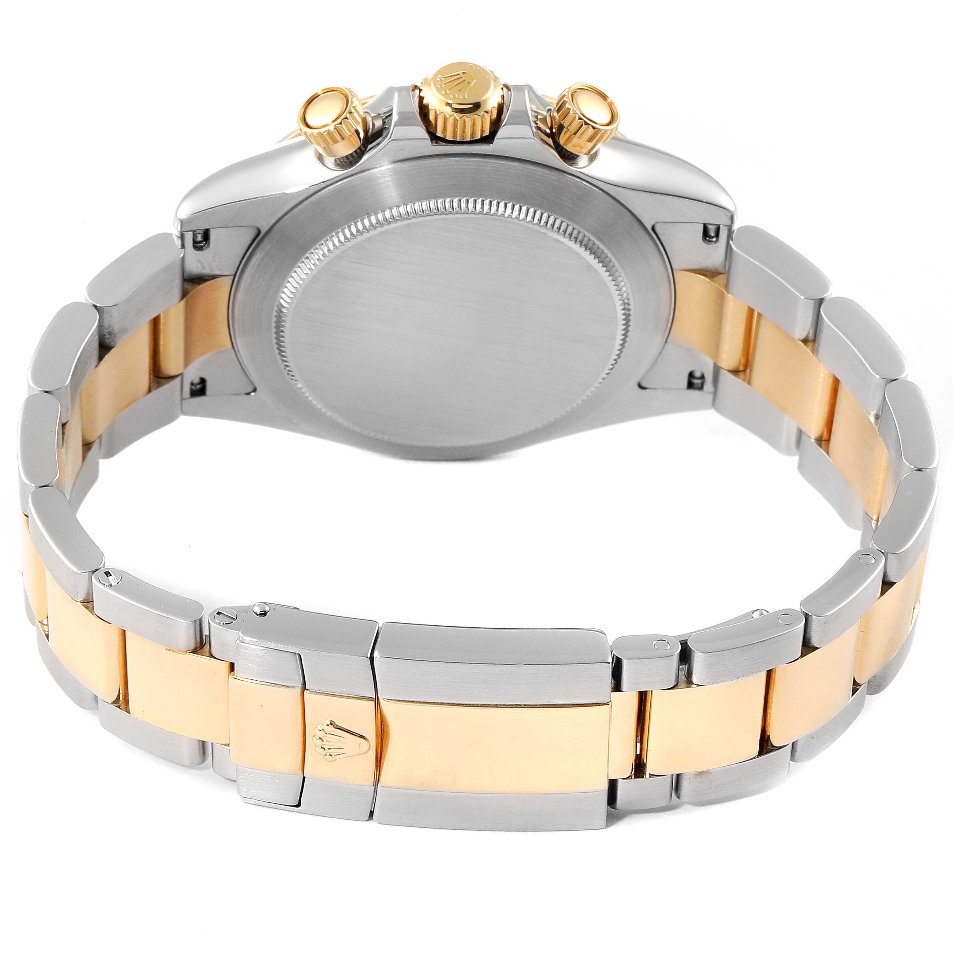 The image shows the back view of a Rolex Daytona 116523 Men
s Steel and Gold (two tone) Black Dial 116523 Men
s Steel and Gold (two tone) Black Dial watch, highlighting the case back, crown, pushers, and two-tone bracelet.