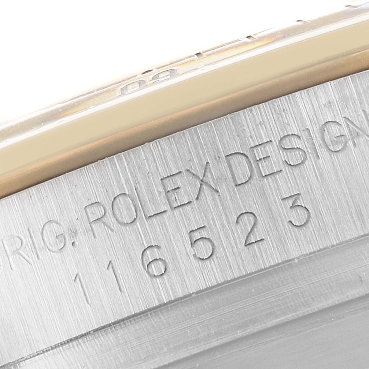 This image shows a close-up of the side of the Rolex Daytona 116523 Men
s Steel and Gold (two tone) Black Dial 116523 Men
s Steel and Gold (two tone) Black Dial watch, focusing on the engraved model number.