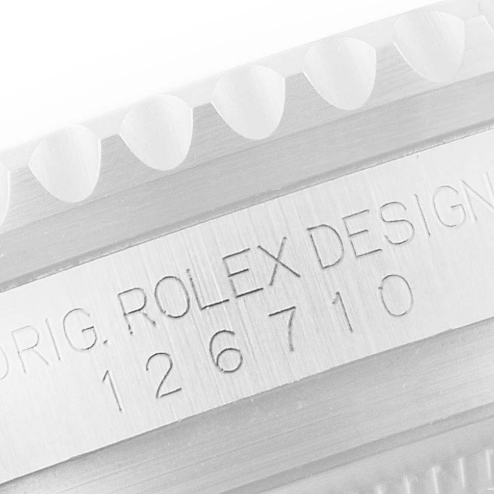 This image shows a close-up of the bezel and engraved serial number on the case of a Rolex GMT-Master 126710 Men's Stainless Steel Black Dial 126710 Men's Stainless Steel Black Dial watch.