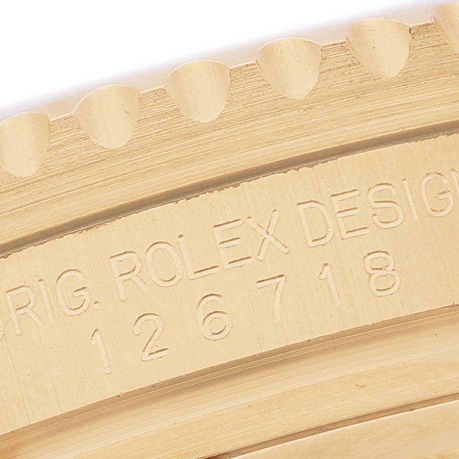 This close-up image shows the engraved side of the Rolex GMT-Master 126718GRNR Men's Yellow Gold Black Dial bezel with a focus on the model number.